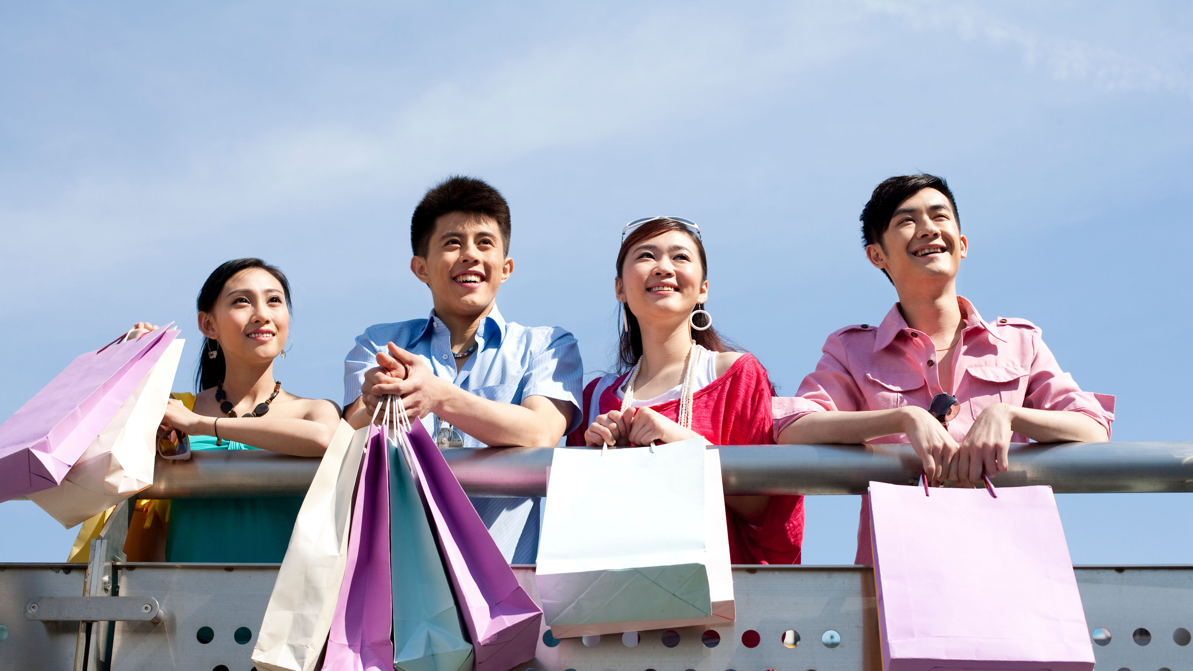 Apat na magkakaibigan na may hawak na shopping bags 