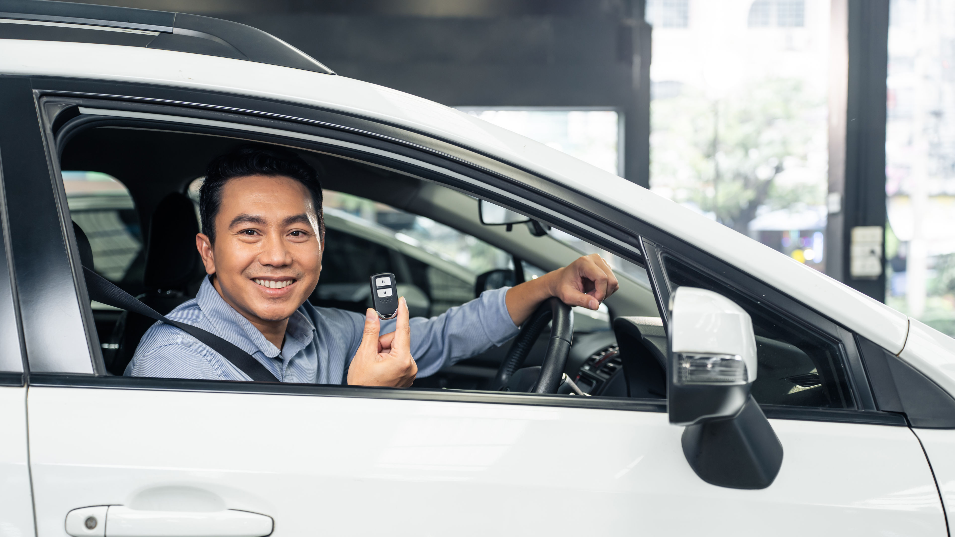 Masayang lalaki na may hawak na remote car key