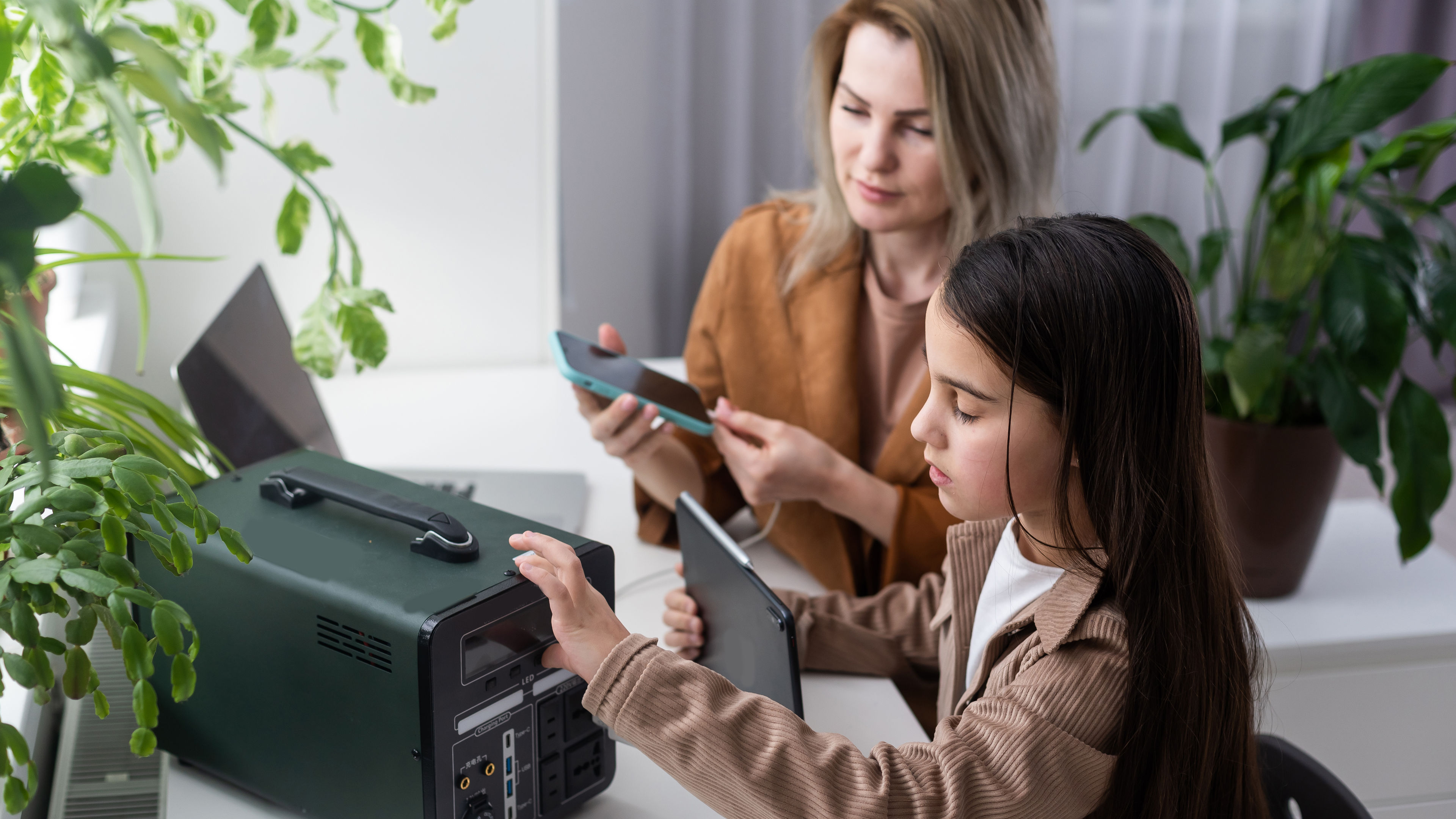 Girl with Adult Using Portable Power Station Indoors