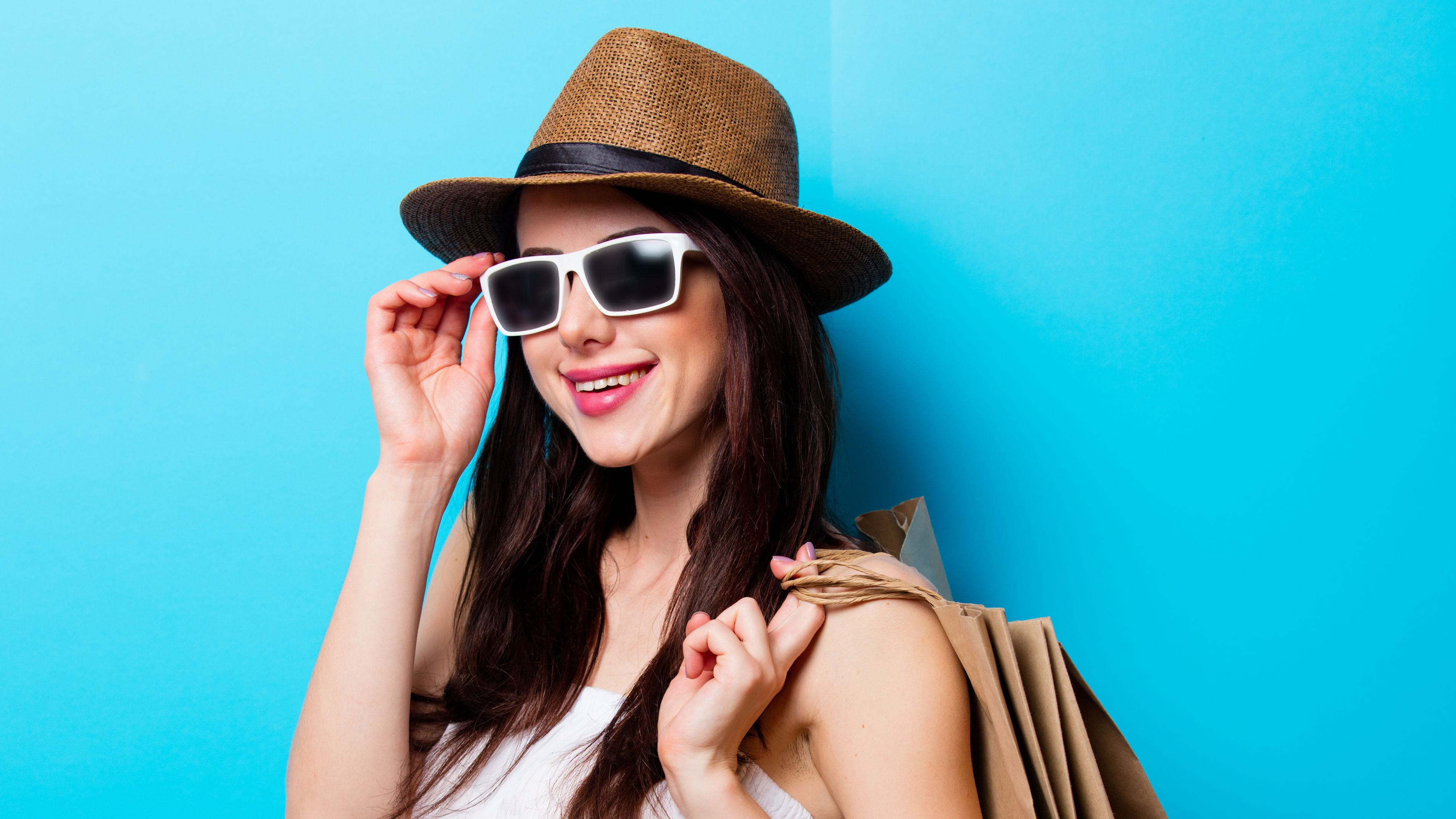 A young woman happily posing with her shopping bags. 
