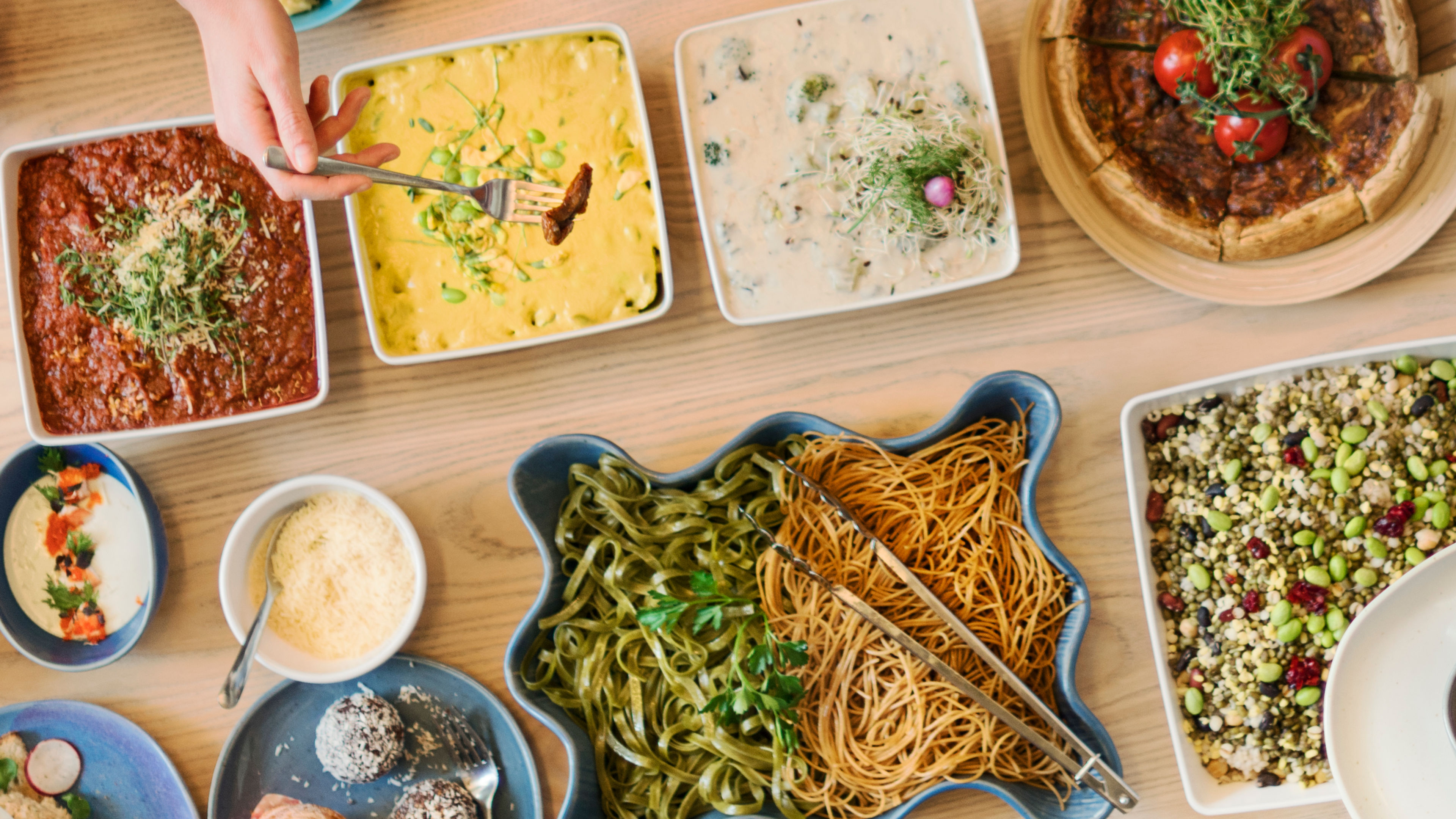 張擺滿各種美食嘅枱，包括意大利面、沙拉、海鮮同甜點 