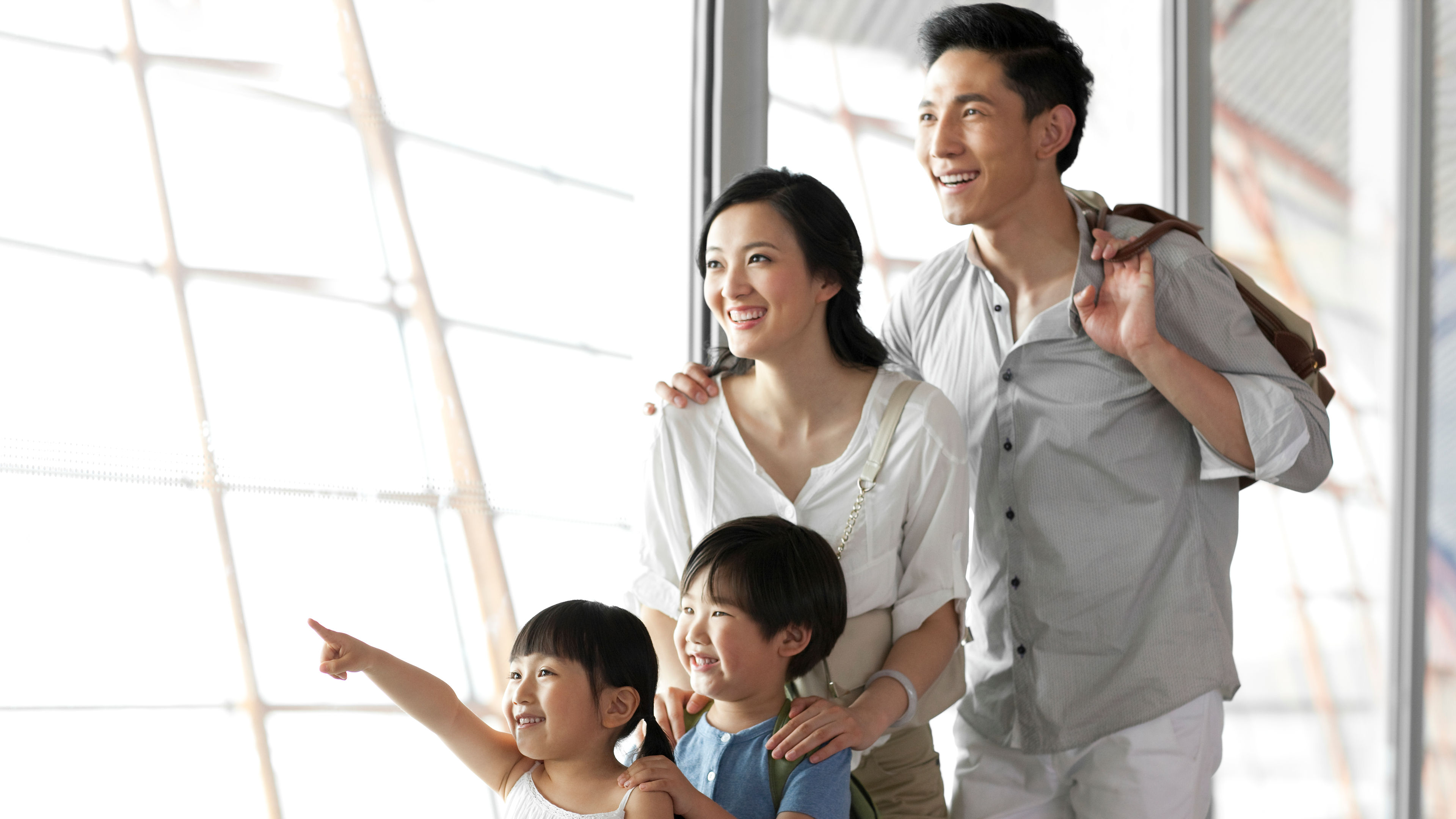A young family of four looking at view at the airport 