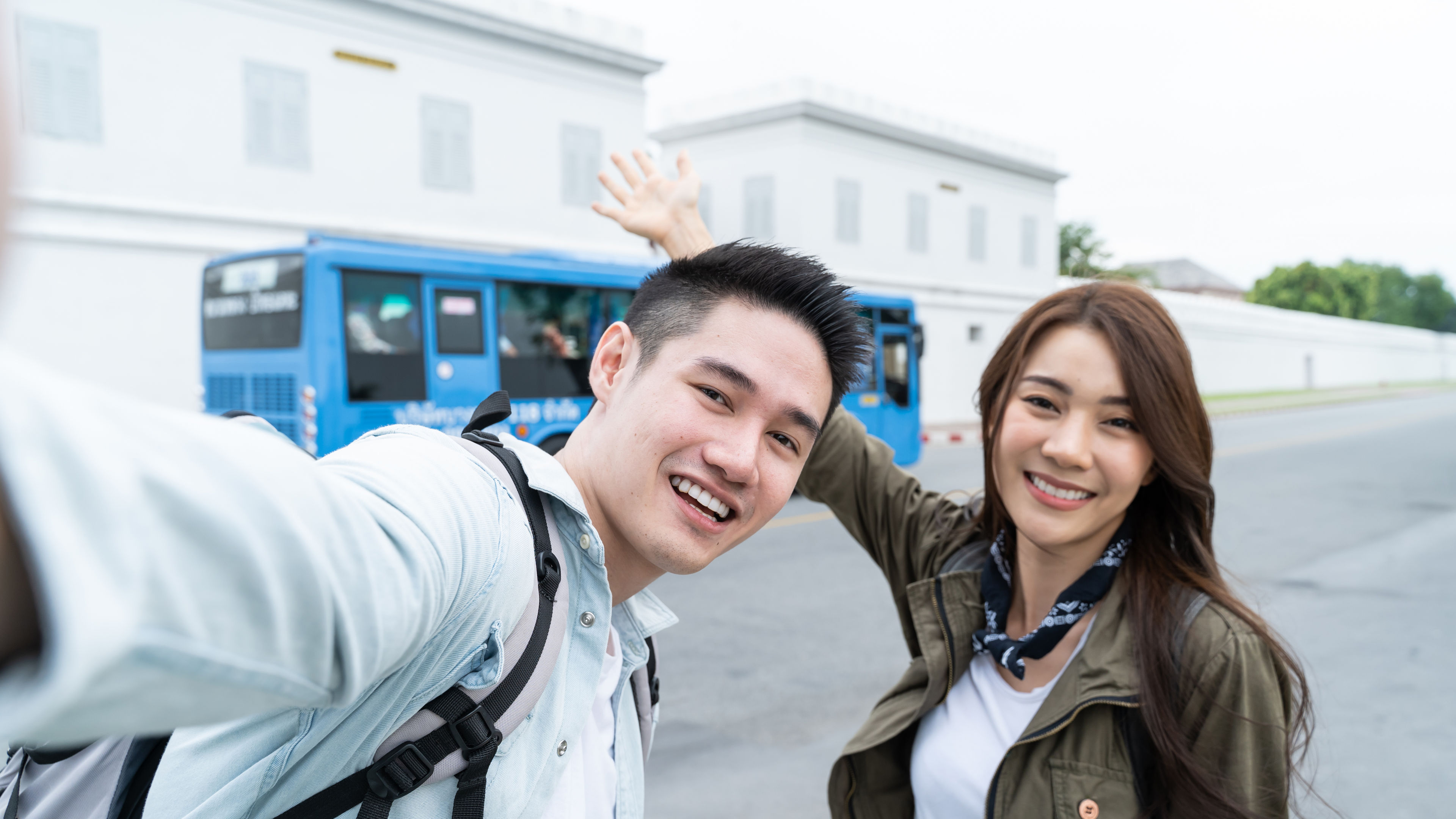 Asian couple backpacker use mobile phone selfie, take picture in city