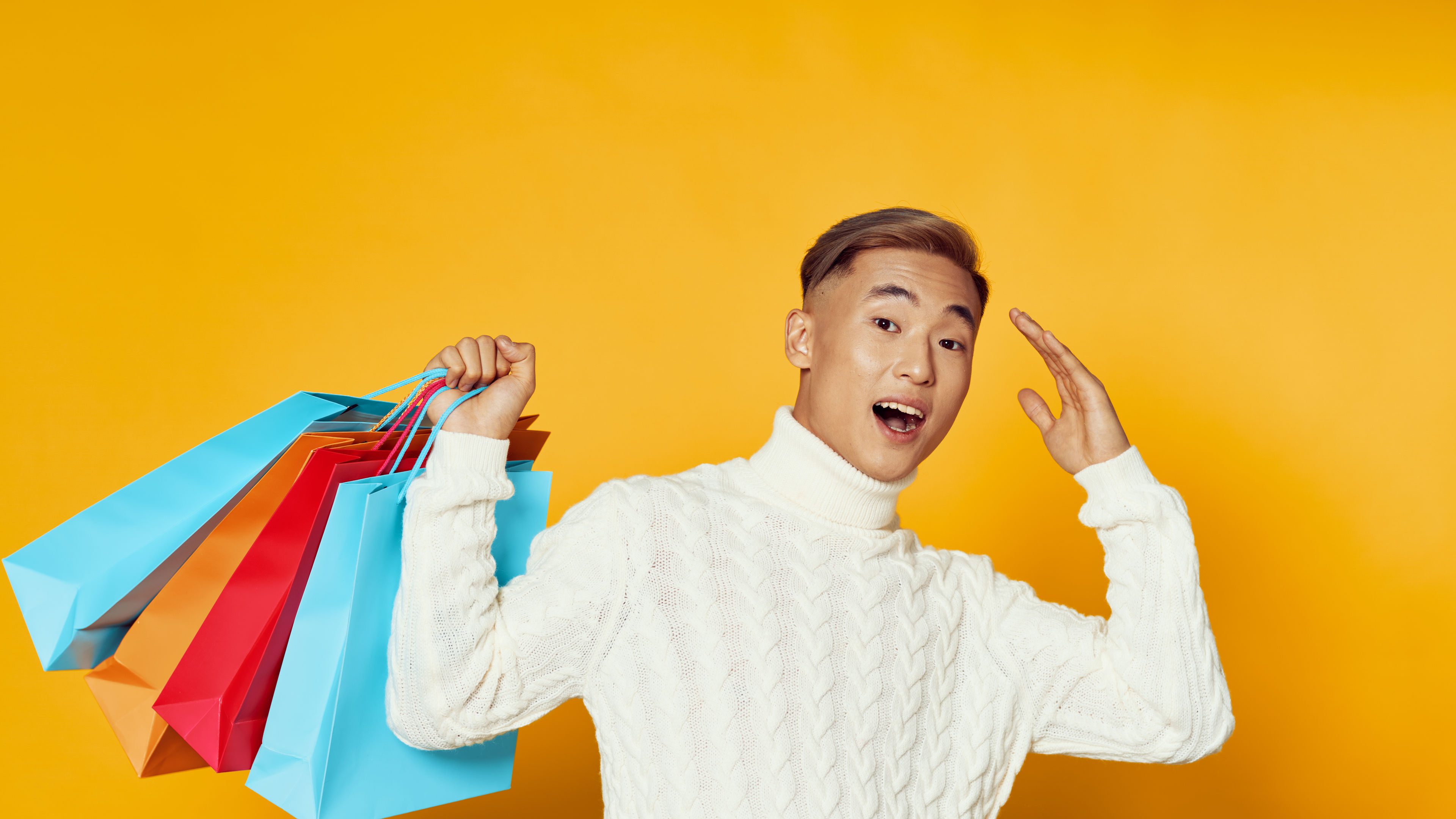 asian man winter sweater shopping gifts yellow background joy 