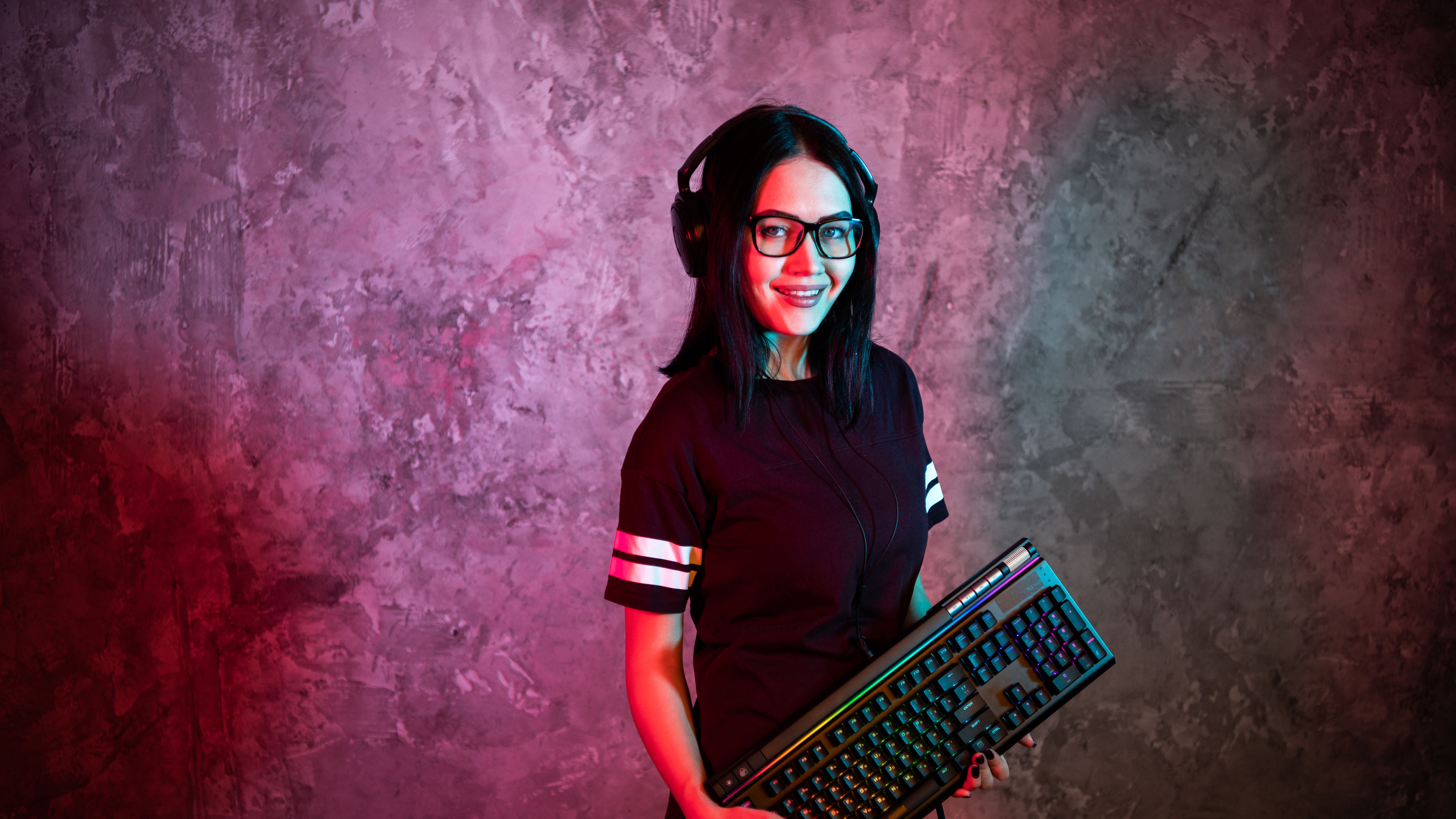 Funny nerd girl wearing glasses carrying computer keyboard