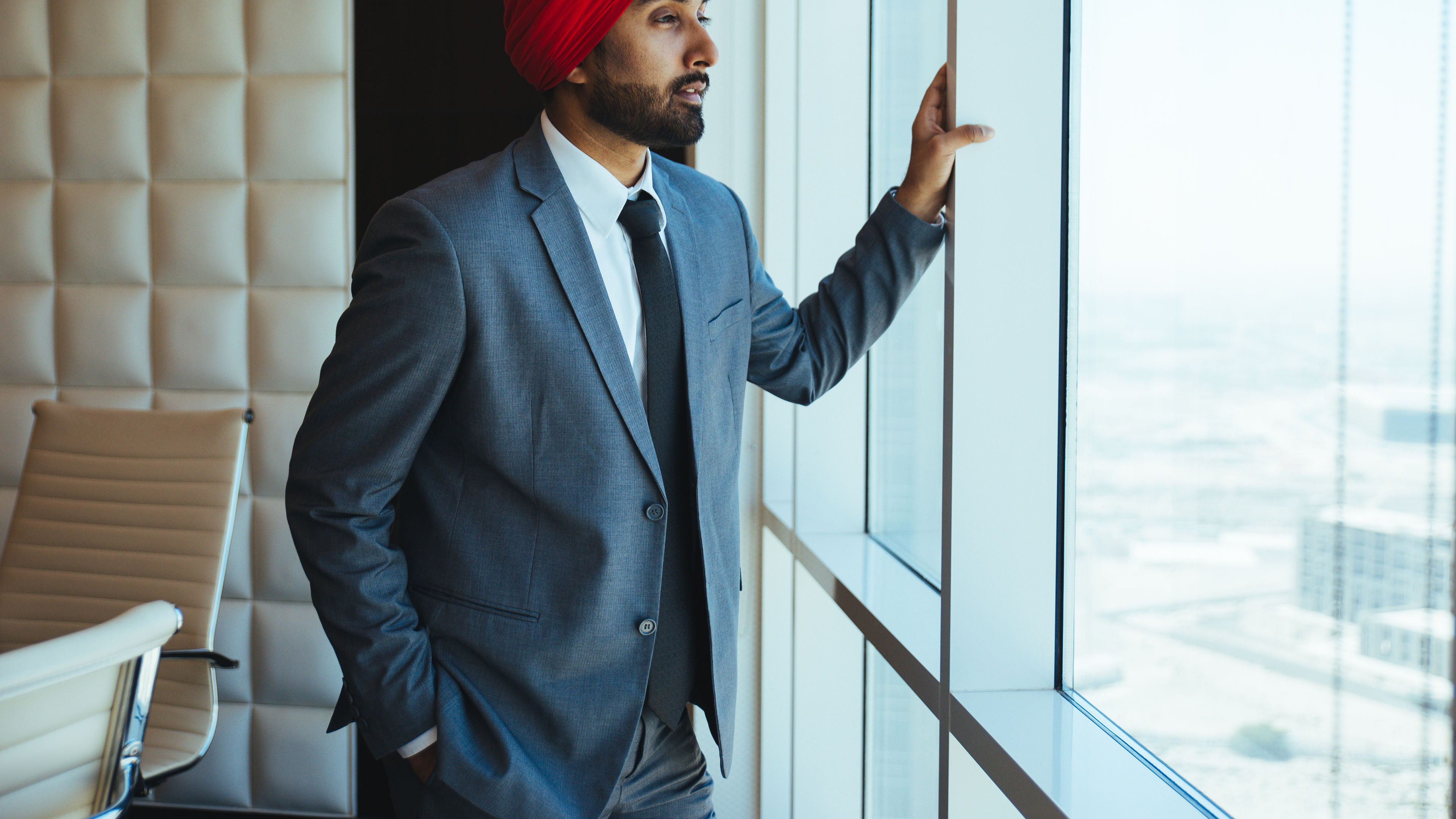 Indian businessman looking out the window in his office