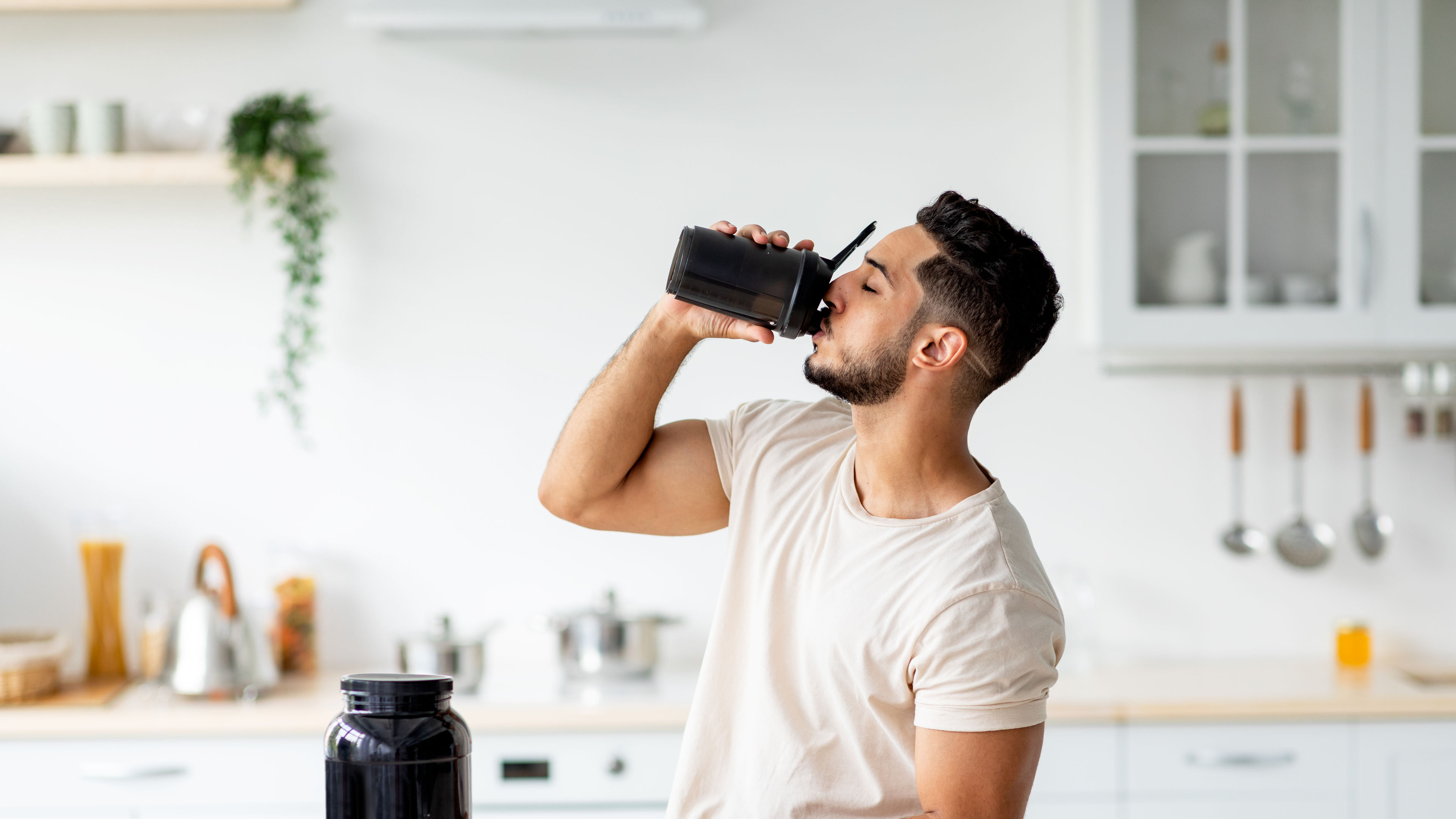 Man Drinking Protein Shake in Bright Kitchen