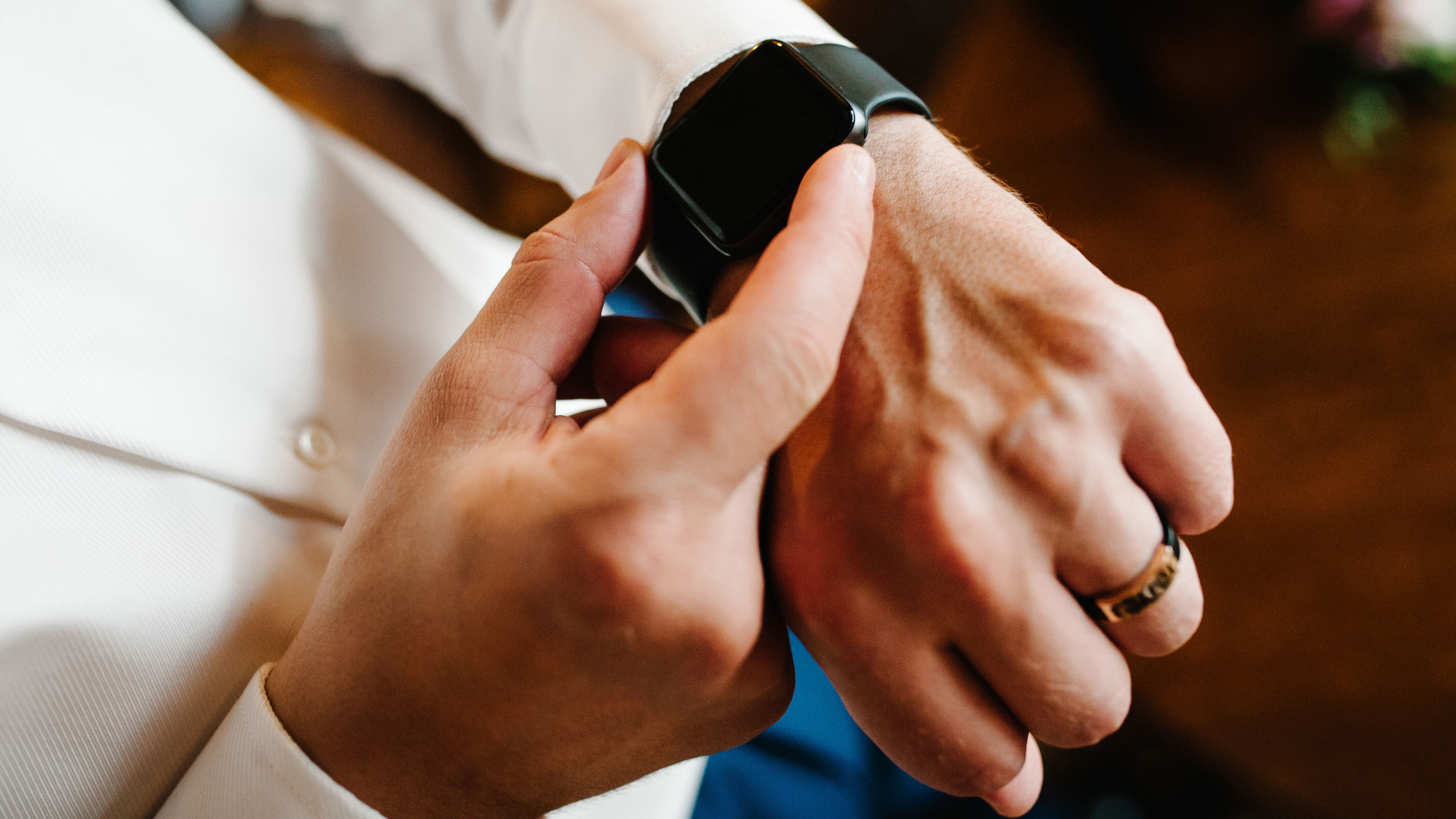 Man in a shirt adjusts the watch on his arm