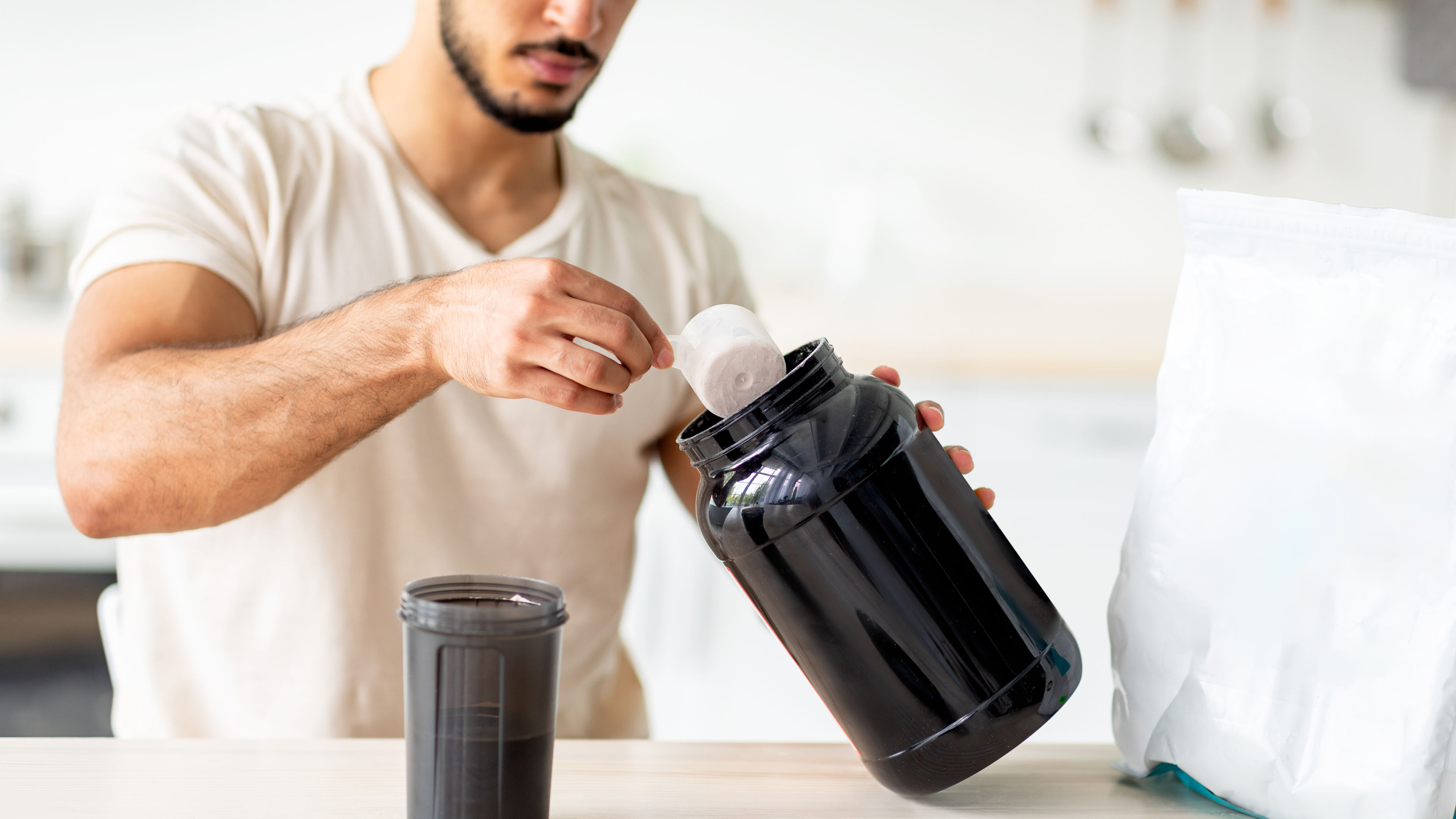 Man Scooping Protein Powder