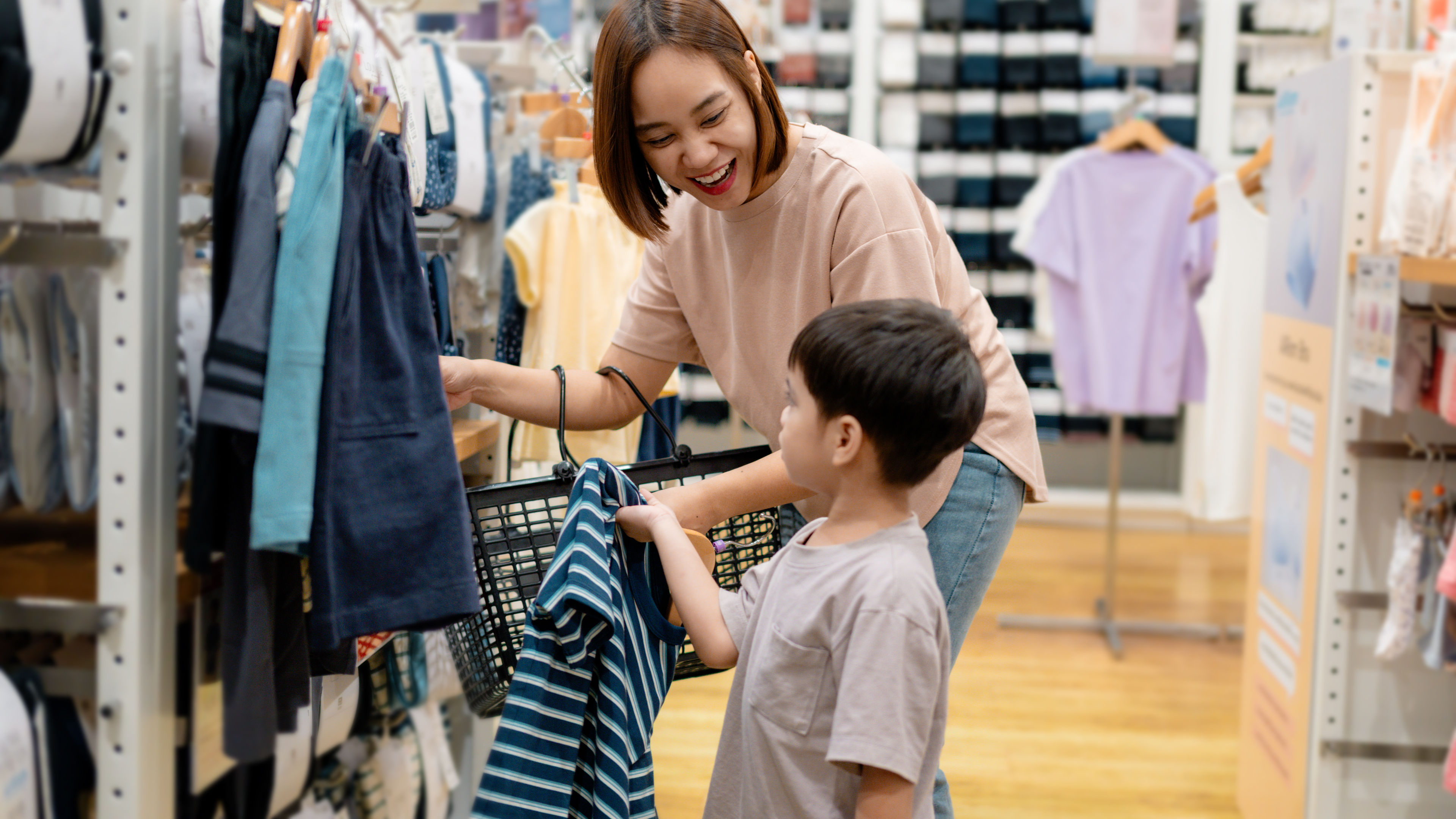 Ibu dan anak yang bahagia memilih pakaian