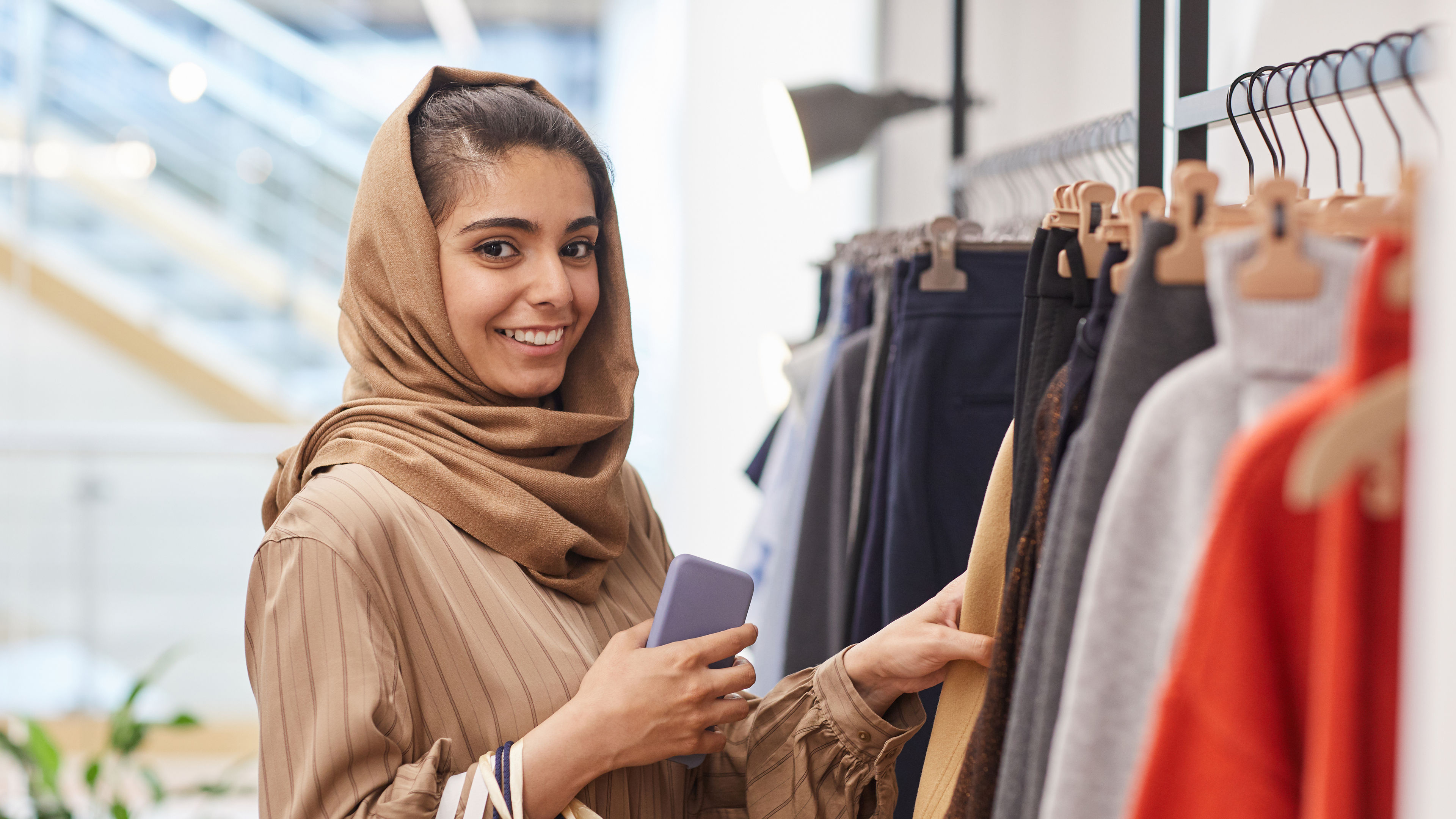 المرأة تتسوق لشراء ملابس جديدة.