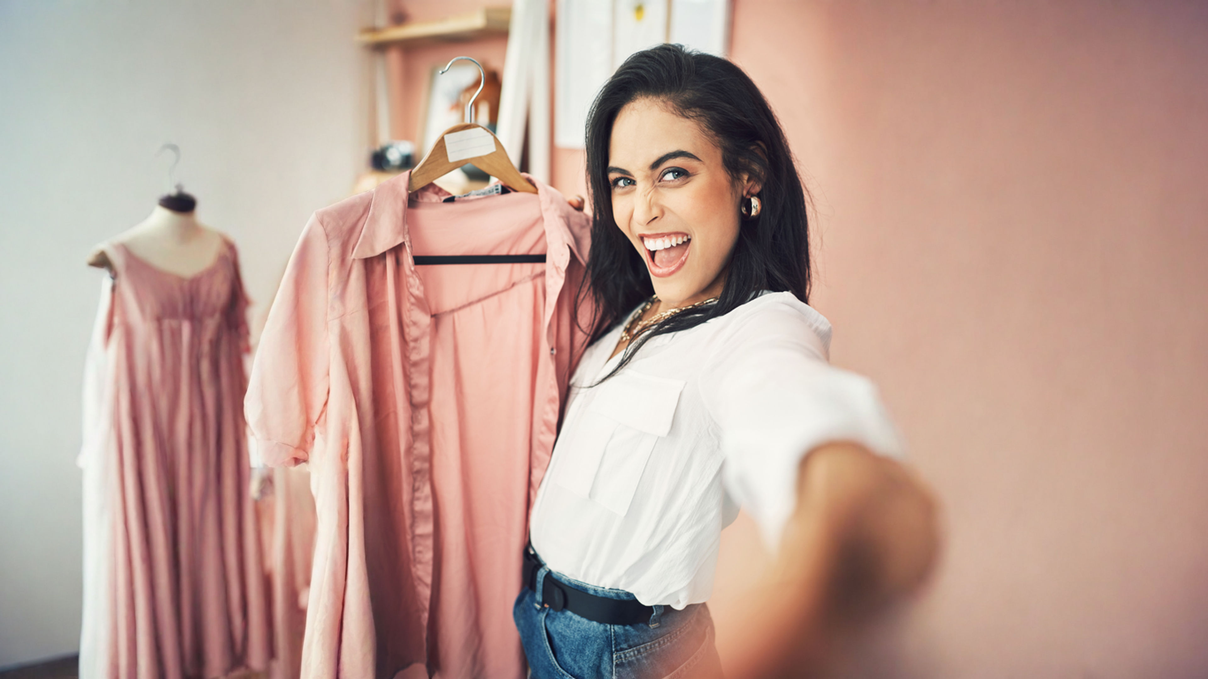 Excited woman showcasing a pink light coloured dress.