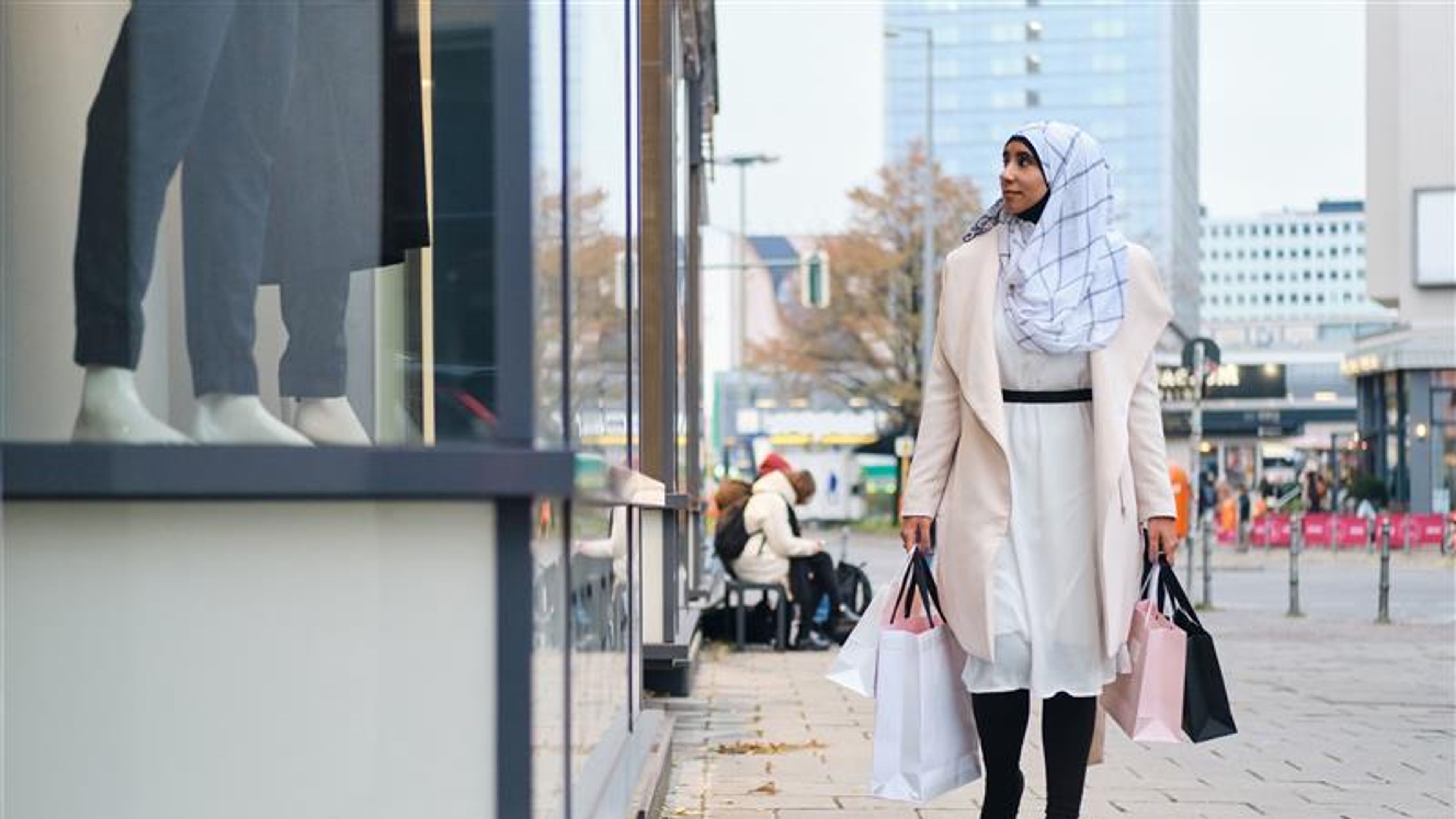 امرأة في مدينة مع حقائب تسوق في متناول اليد 