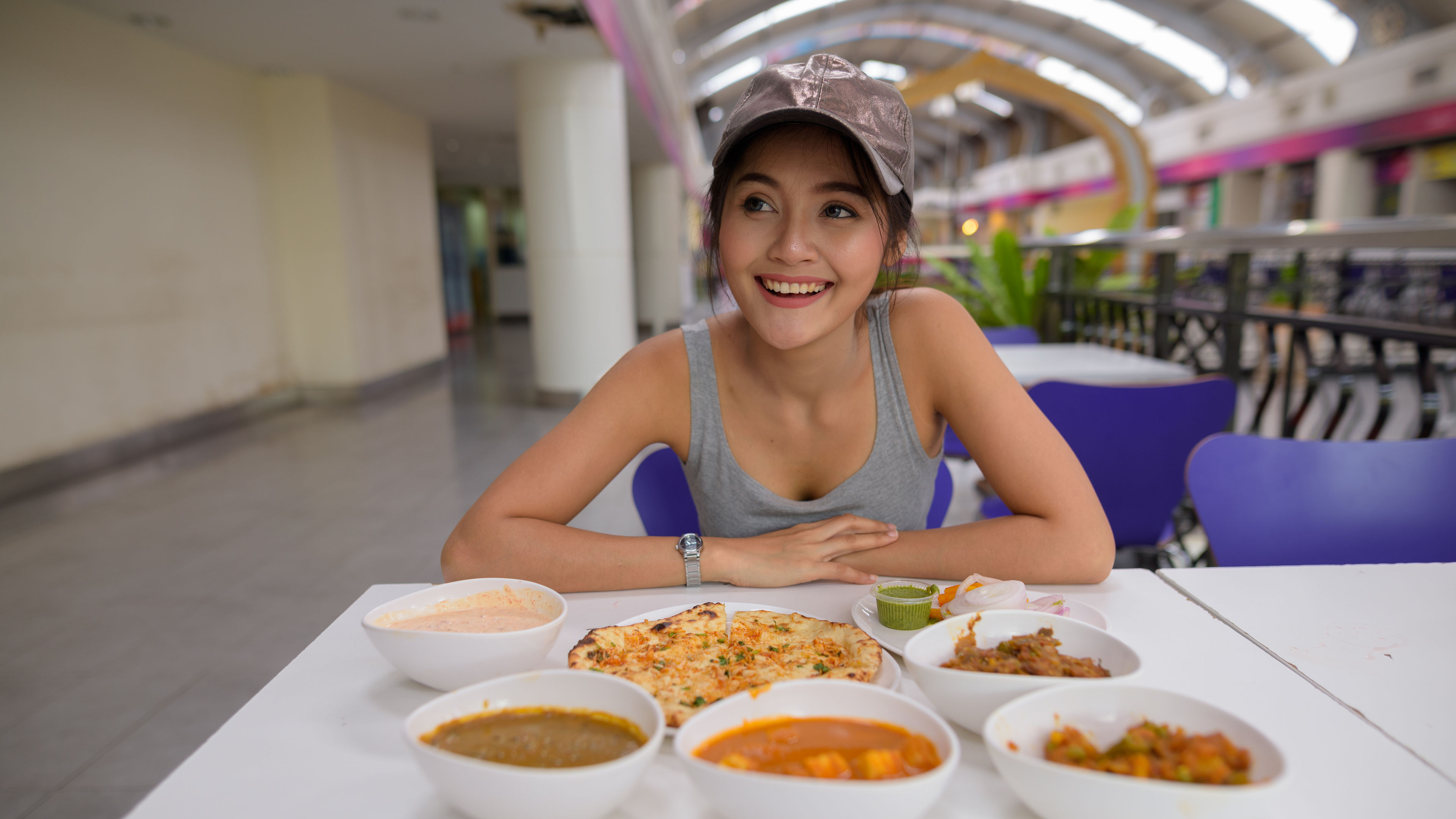 A young woman happily enjoys a variety of dishes at airport. 

 