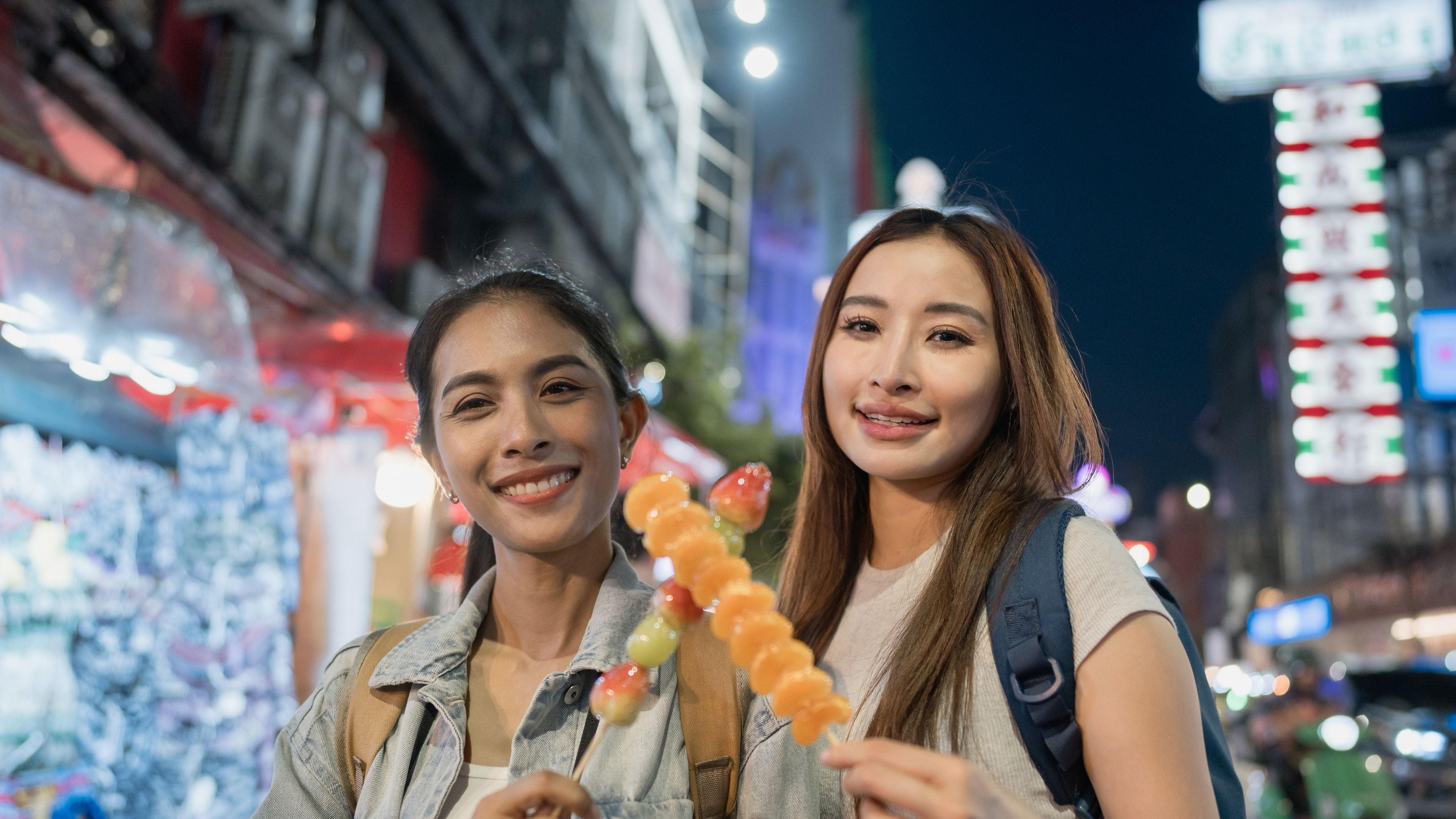 Two young women enjoying street food