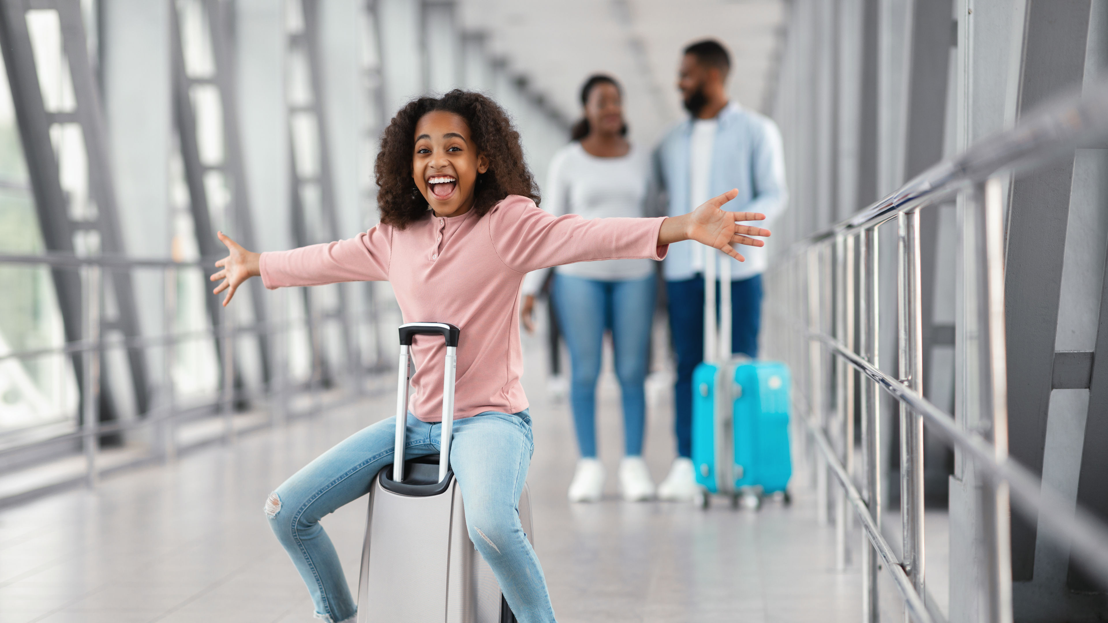 Happy black family traveling with kid, walking in airport