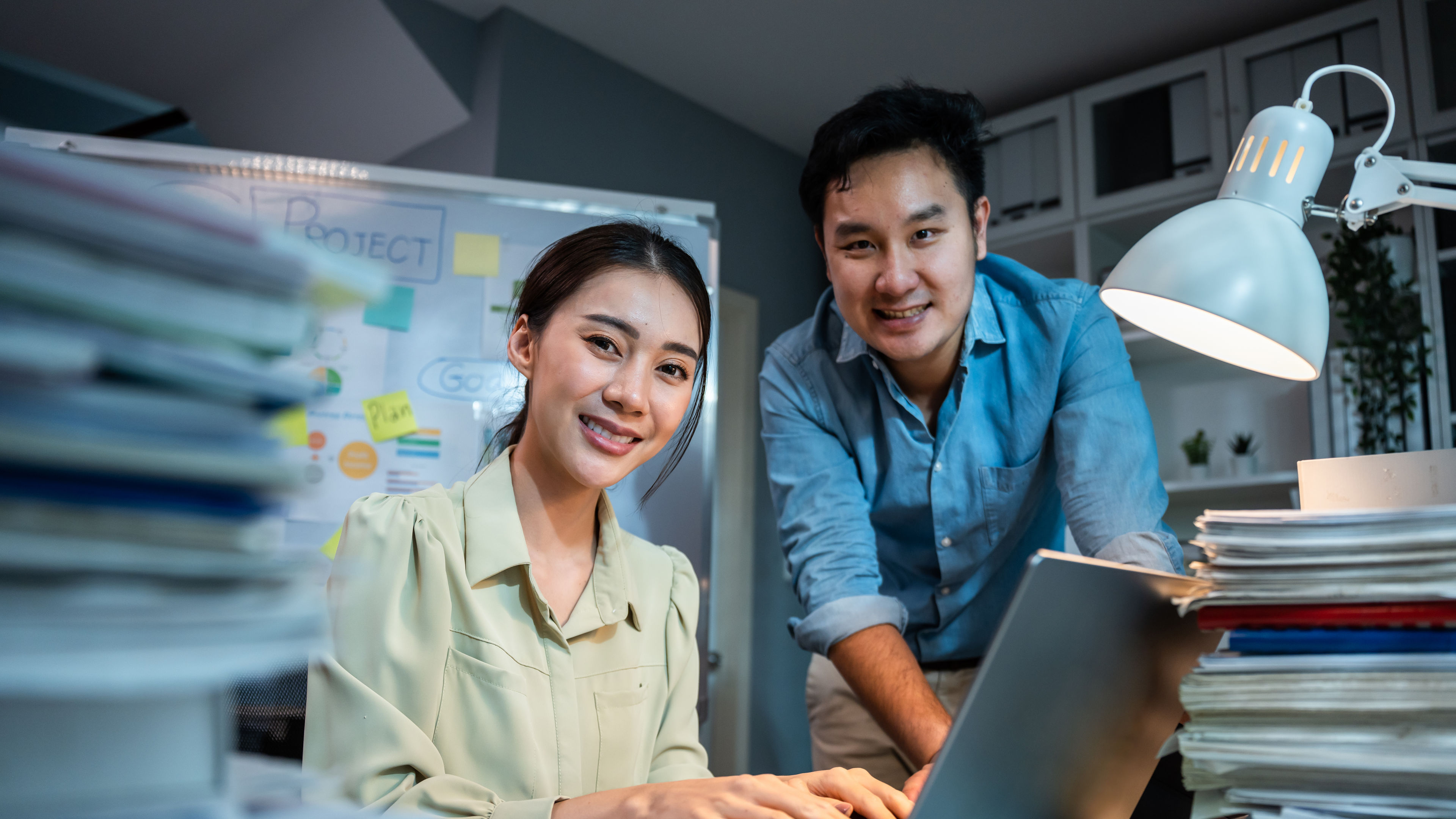Portrait of Asian businessman and woman smiling while work in office. 