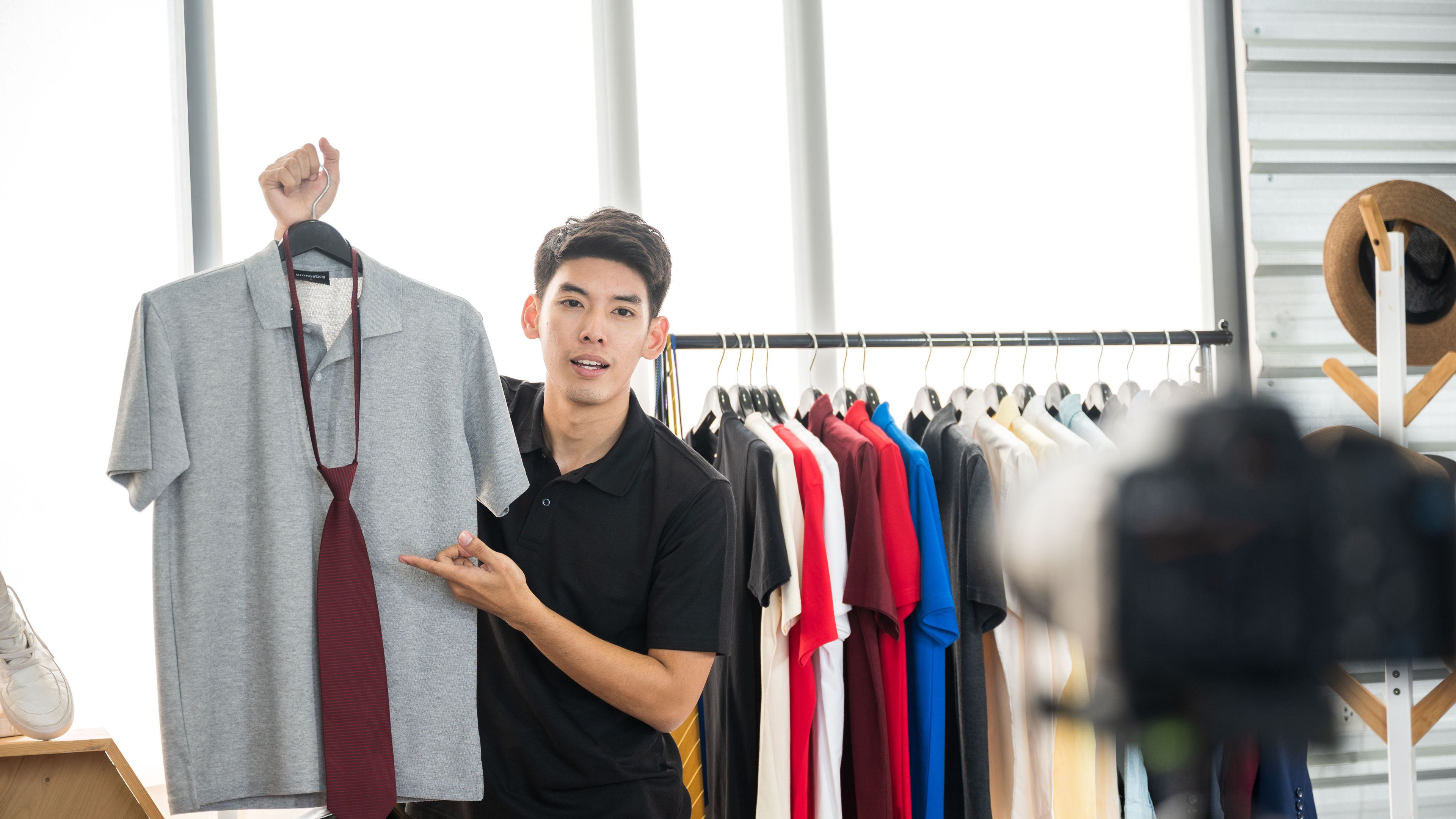 Young men recording videos for selling shirts online. 