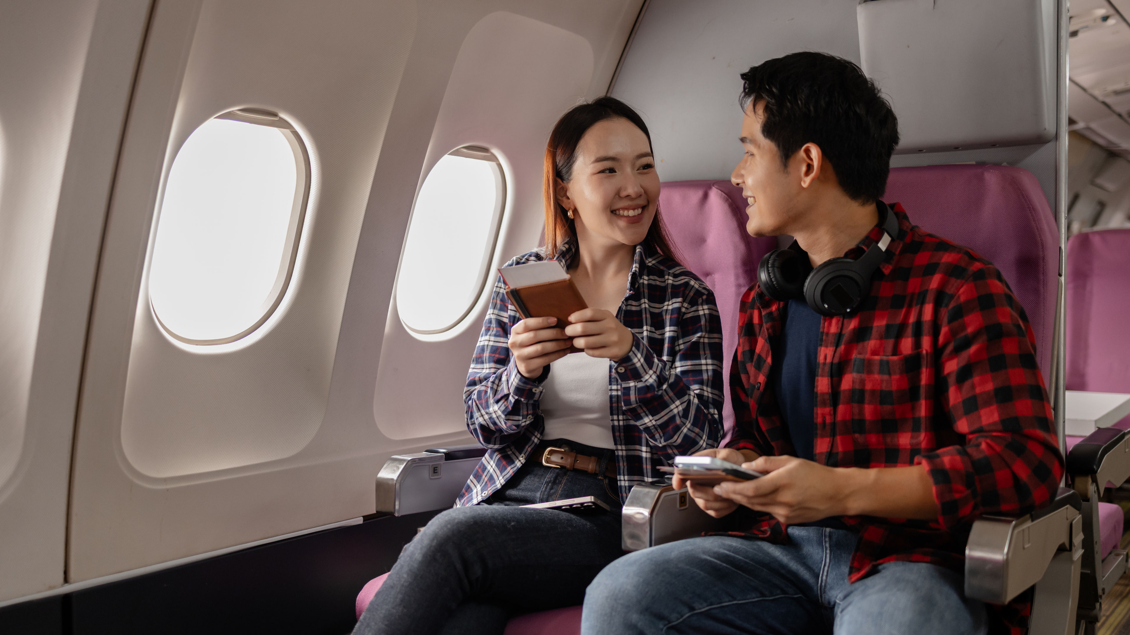 Happy couple sitting on an aeroplane 