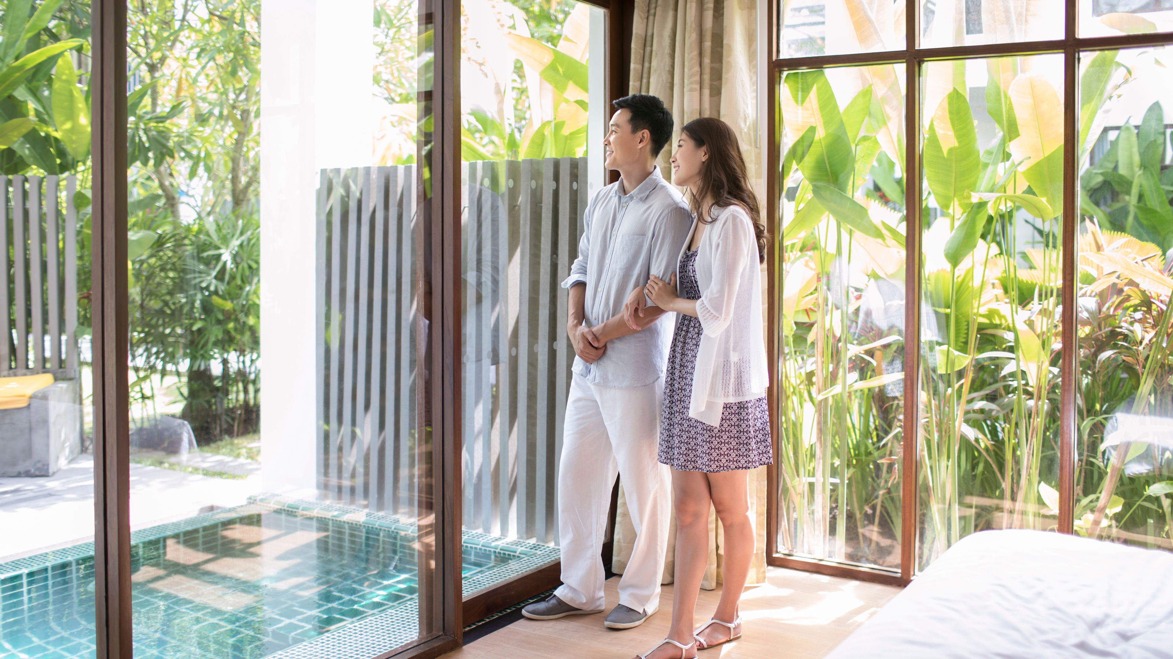 คู่รักหนุ่มสาวชาวจีนที่มีความสุขในห้องพักของโรงแรม