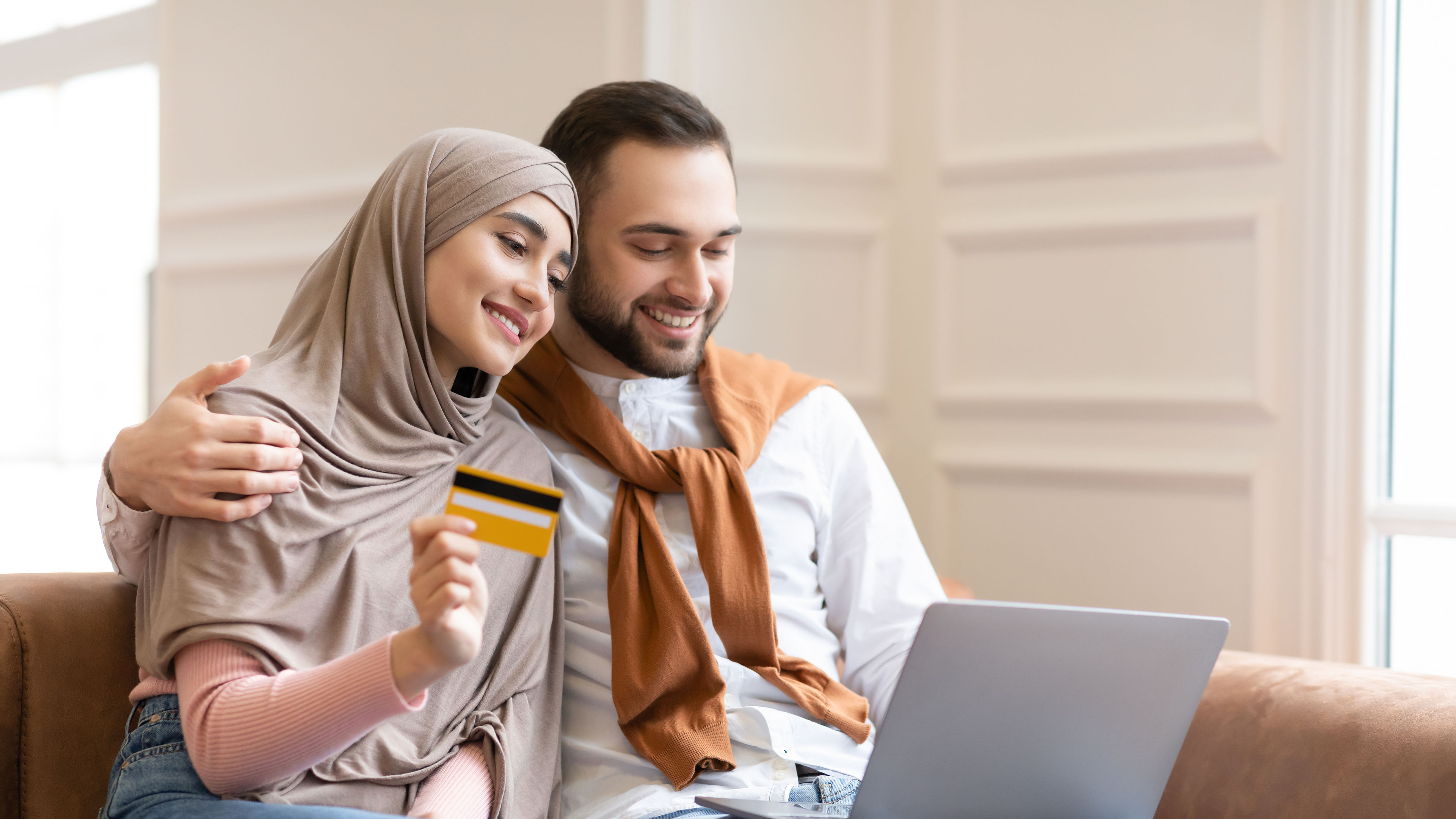A happy, young couple shopping online with a credit card 