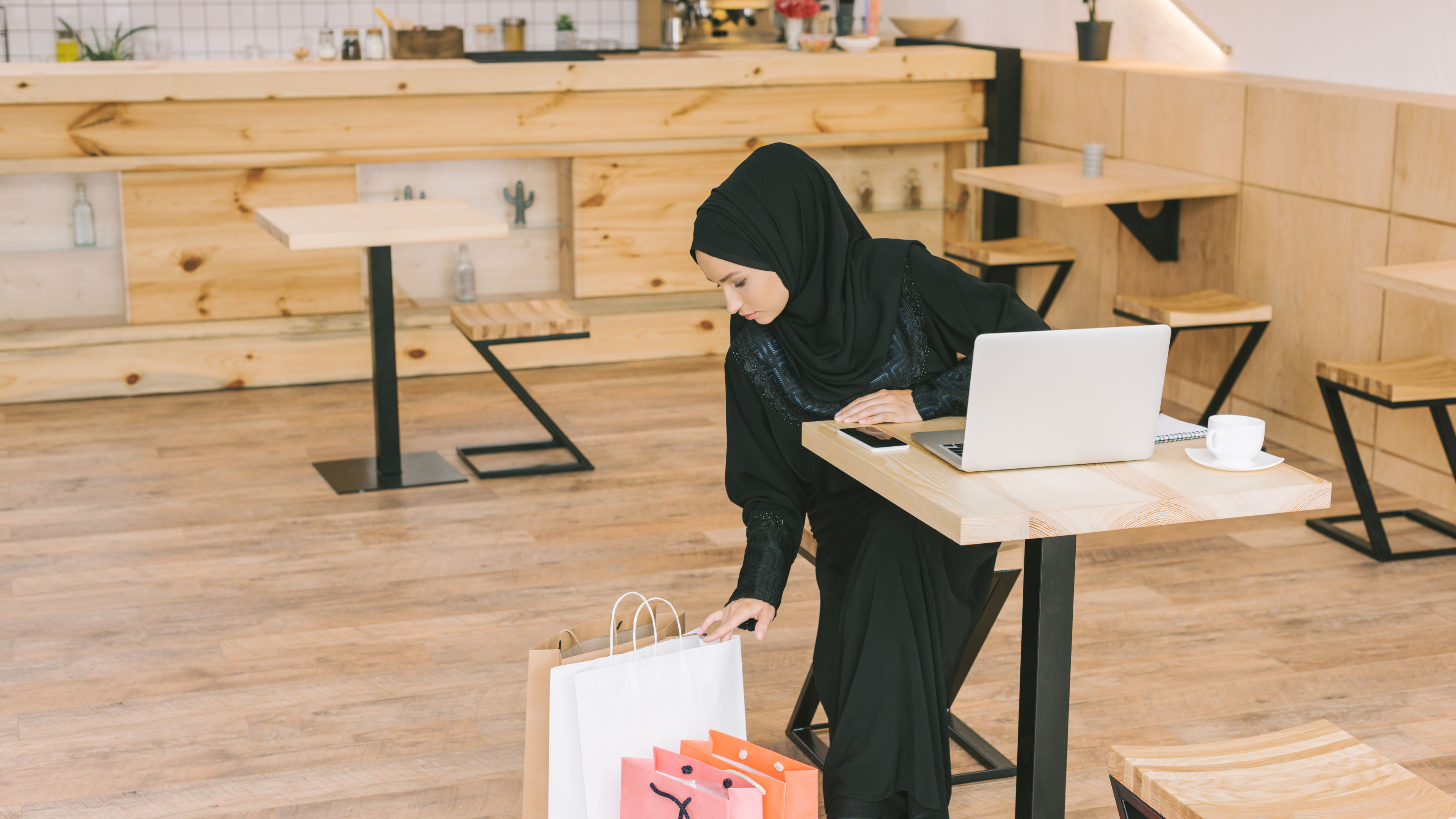 An arabian woman looking at shopping bags after purchasing 