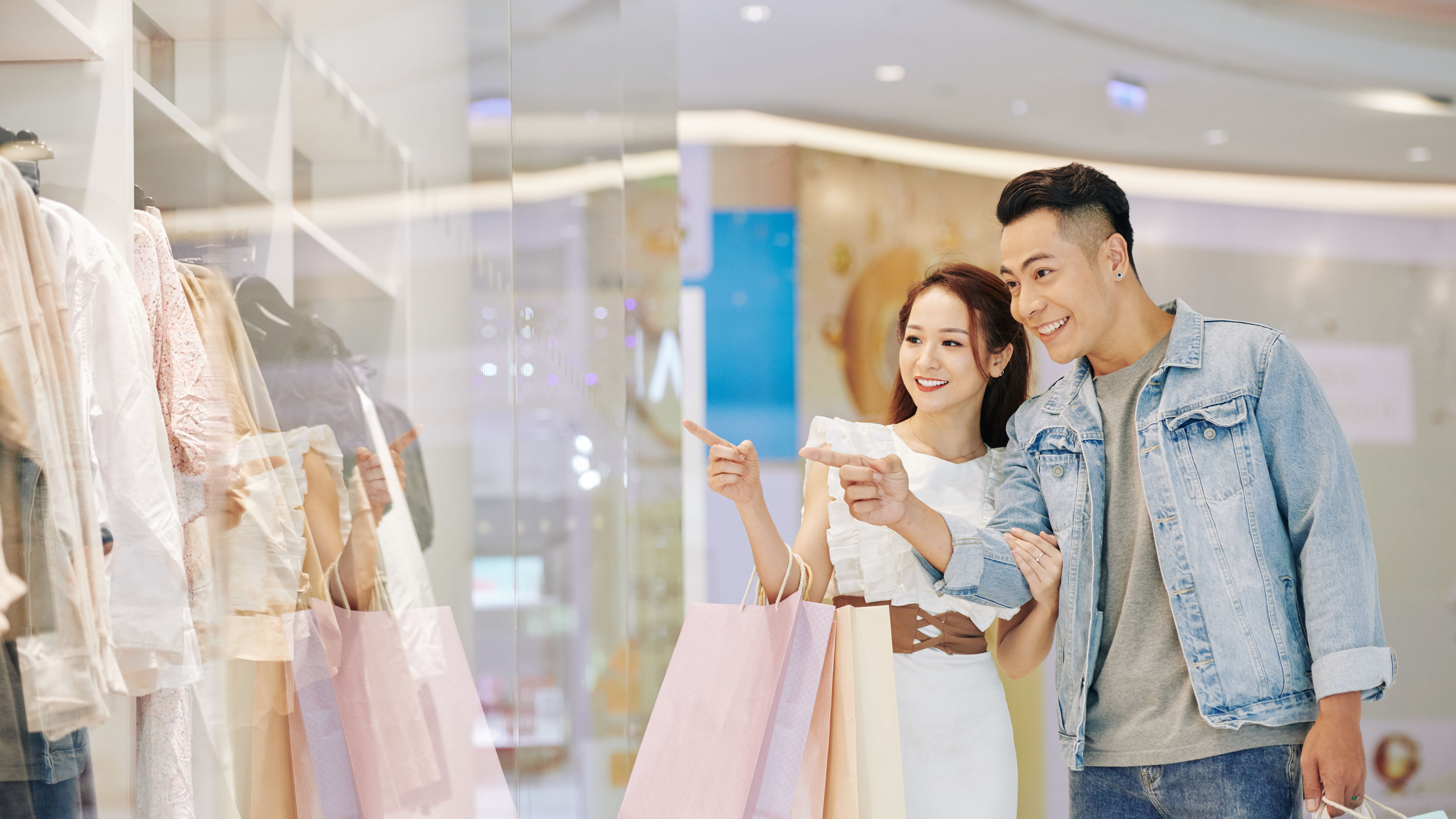 Bạn trai và bạn gái cùng nhau mua sắm, cầm túi trong một cửa hàng bán lẻ.