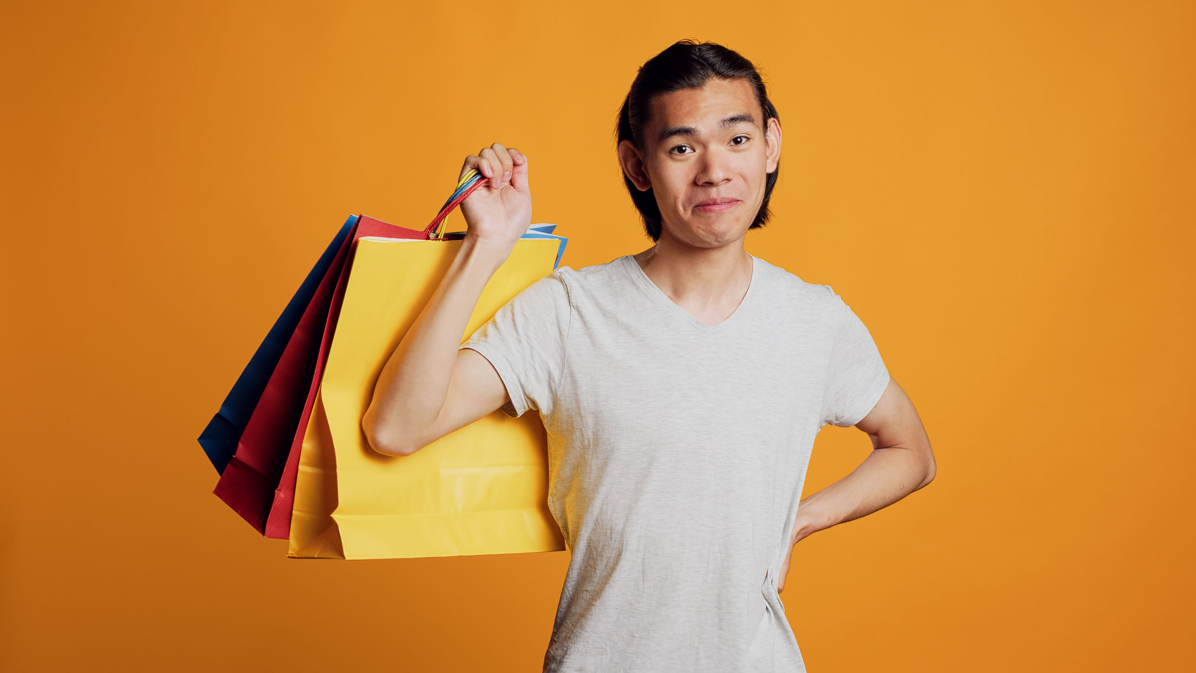 Một người đàn ông vui mừng tự hào mang theo túi mua sắm sau khi mua hàng thành công.