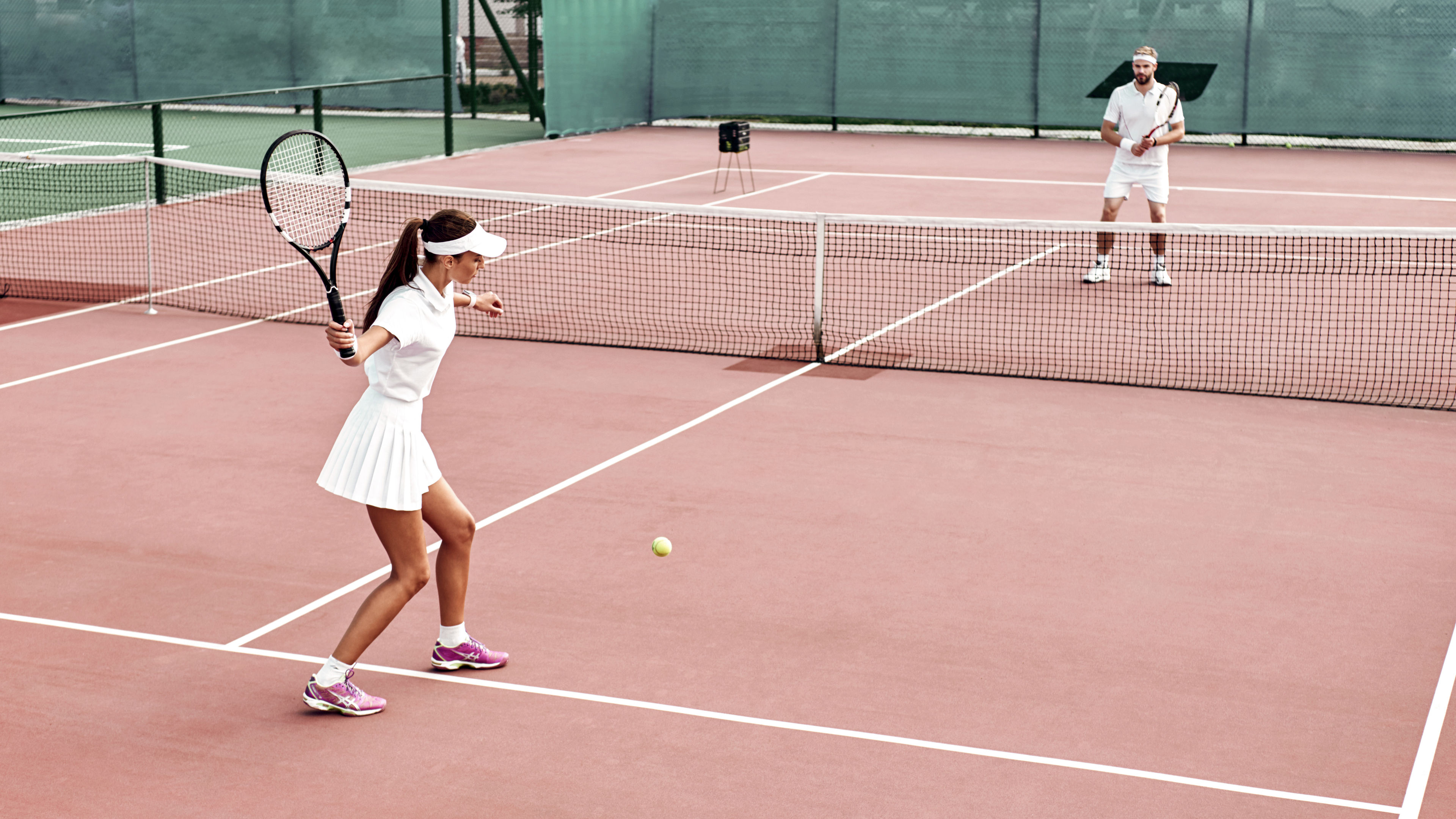 A woman is playing tennis on an outdoor court