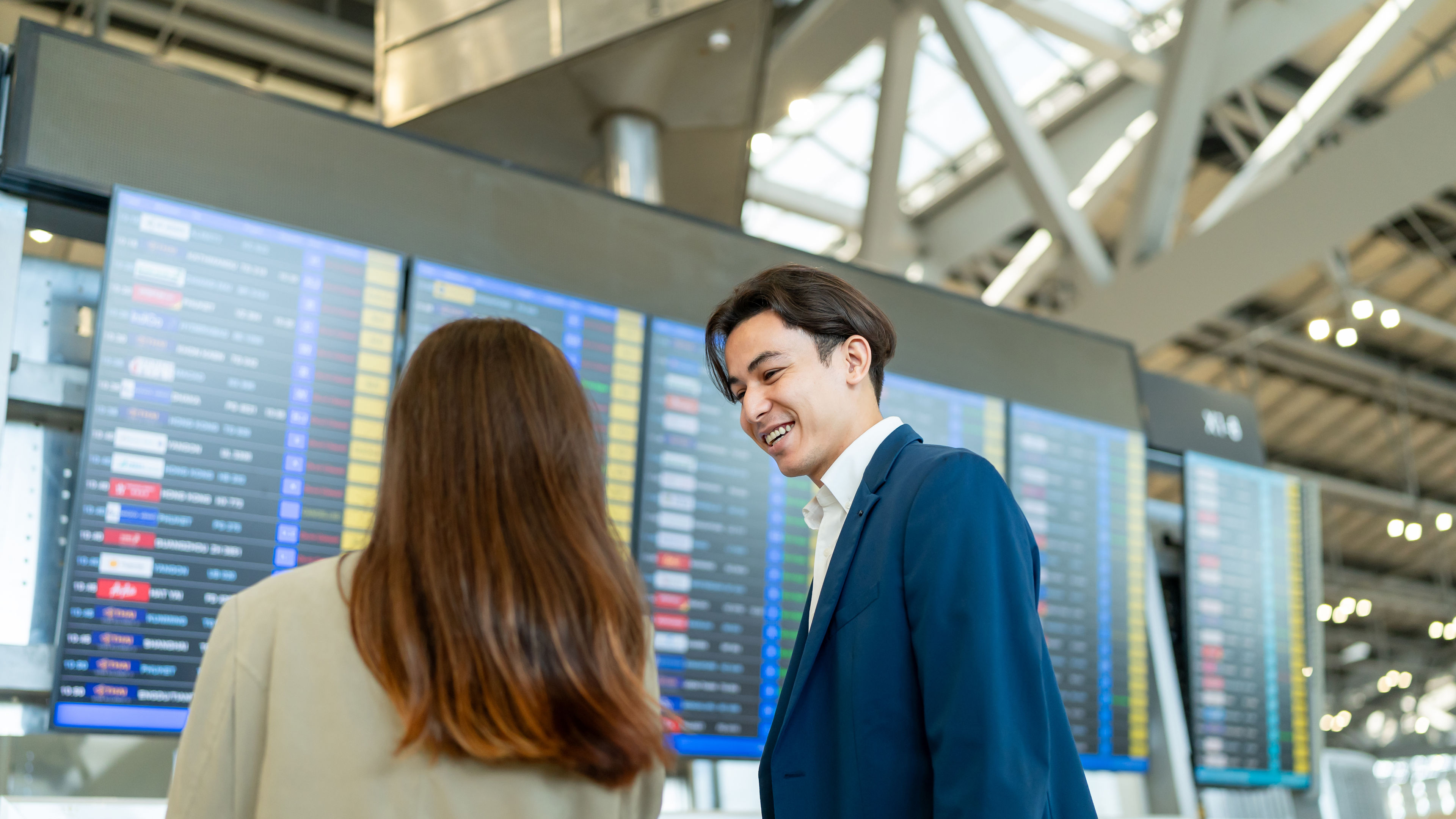 Doanh nhân và phụ nữ kiểm tra thông tin chuyến bay theo lịch trình tại sân bay