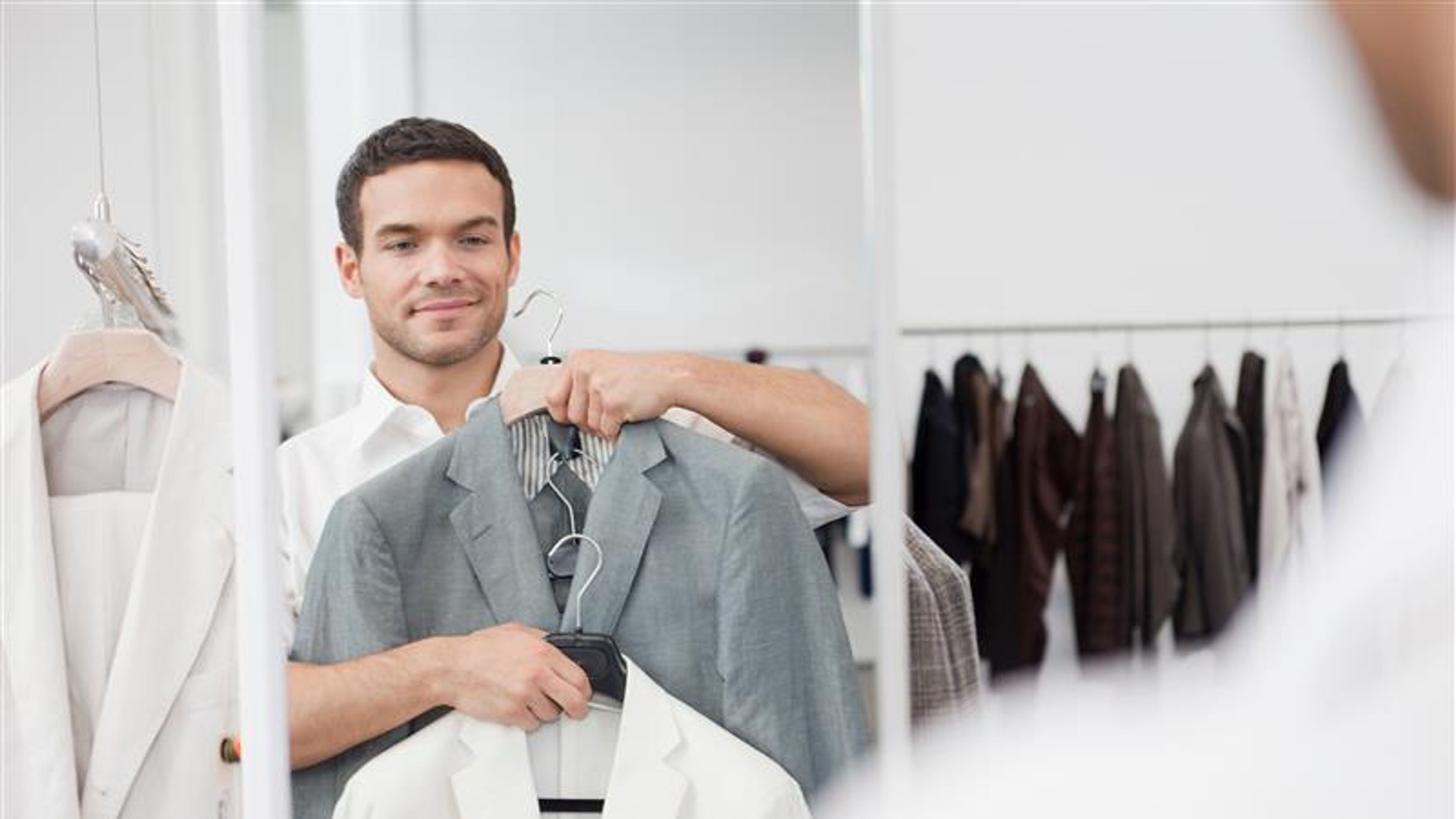 A young man shopping for some suits 