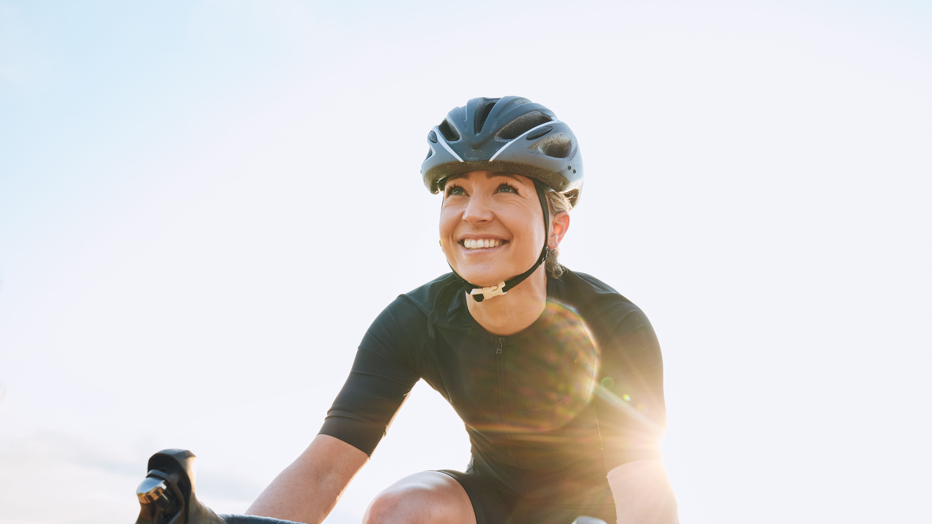 A woman cycling and wearing jacket