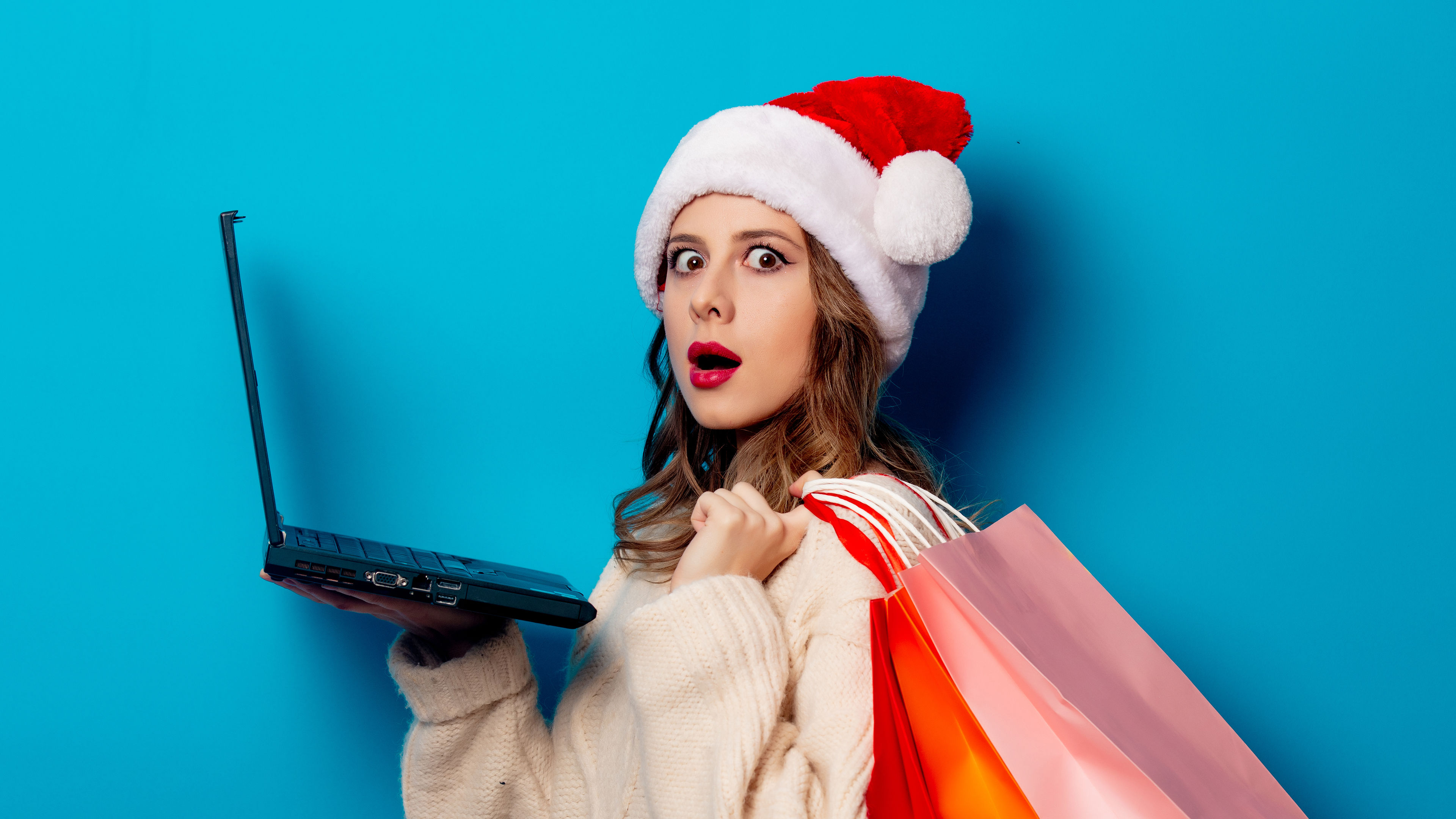 Beautiful woman with shopping bags and laptop computer 