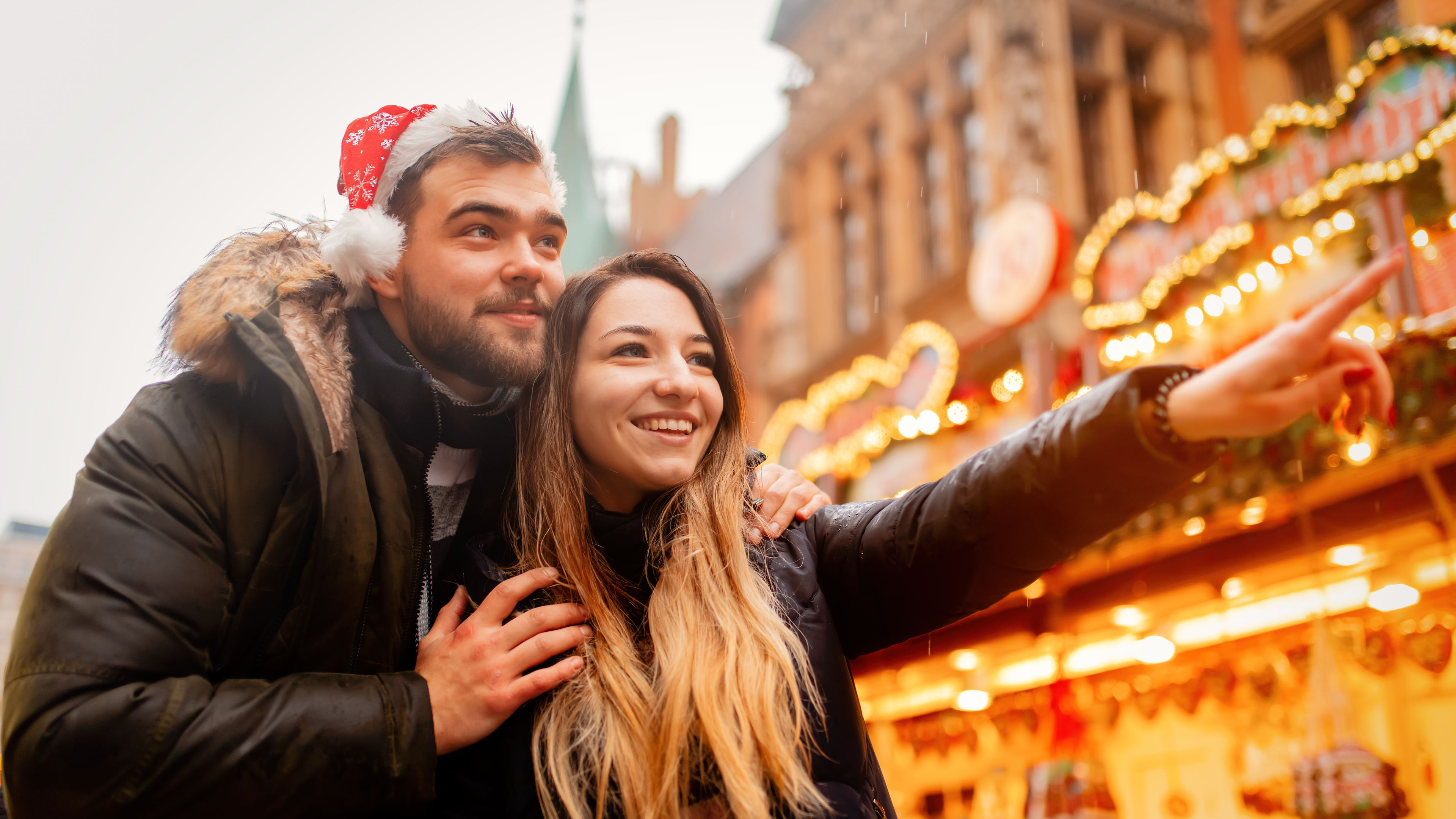 A young couple enjoying their time together at a Christmas market. 
