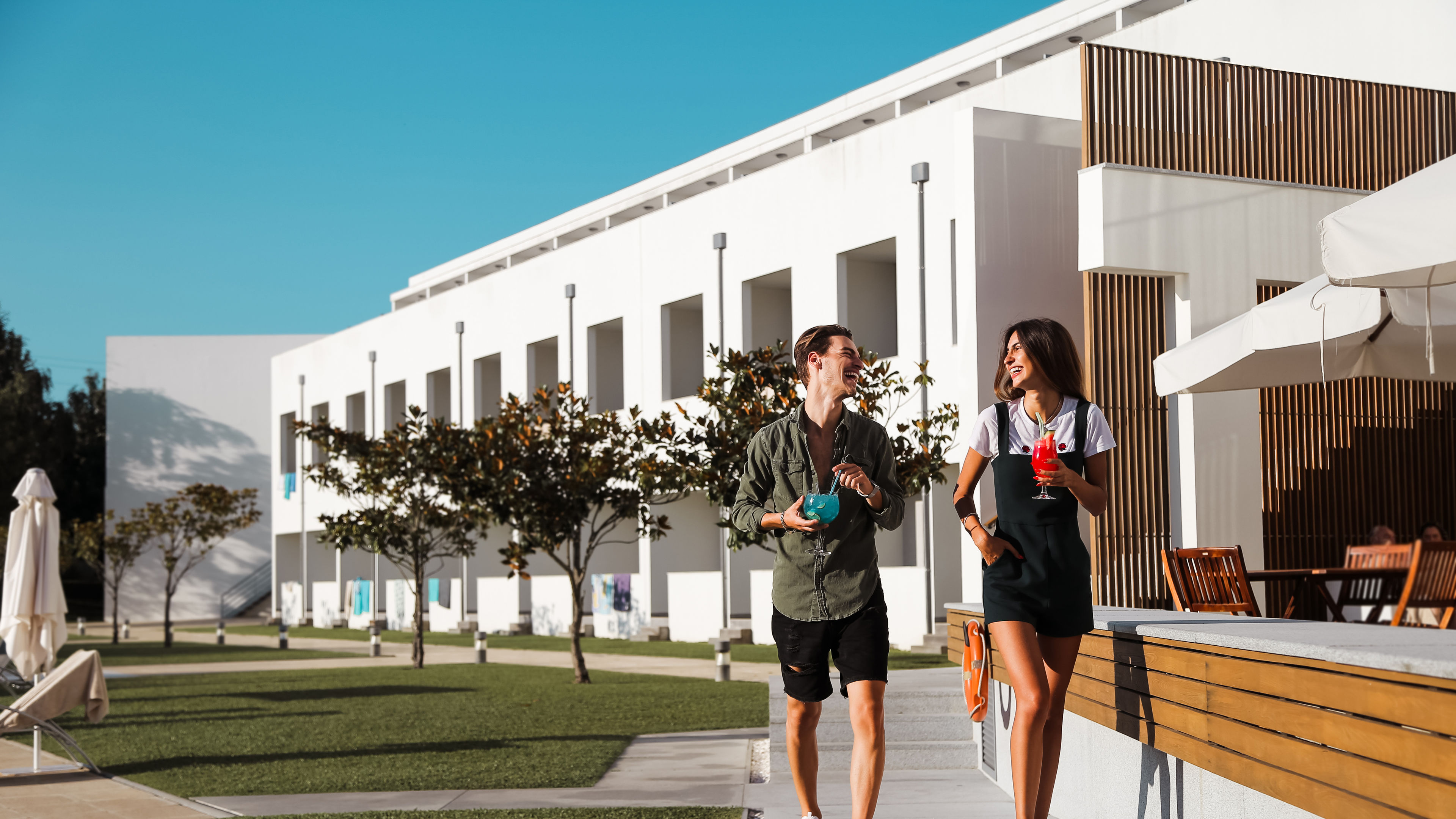 A couple walking by the side of a pool 