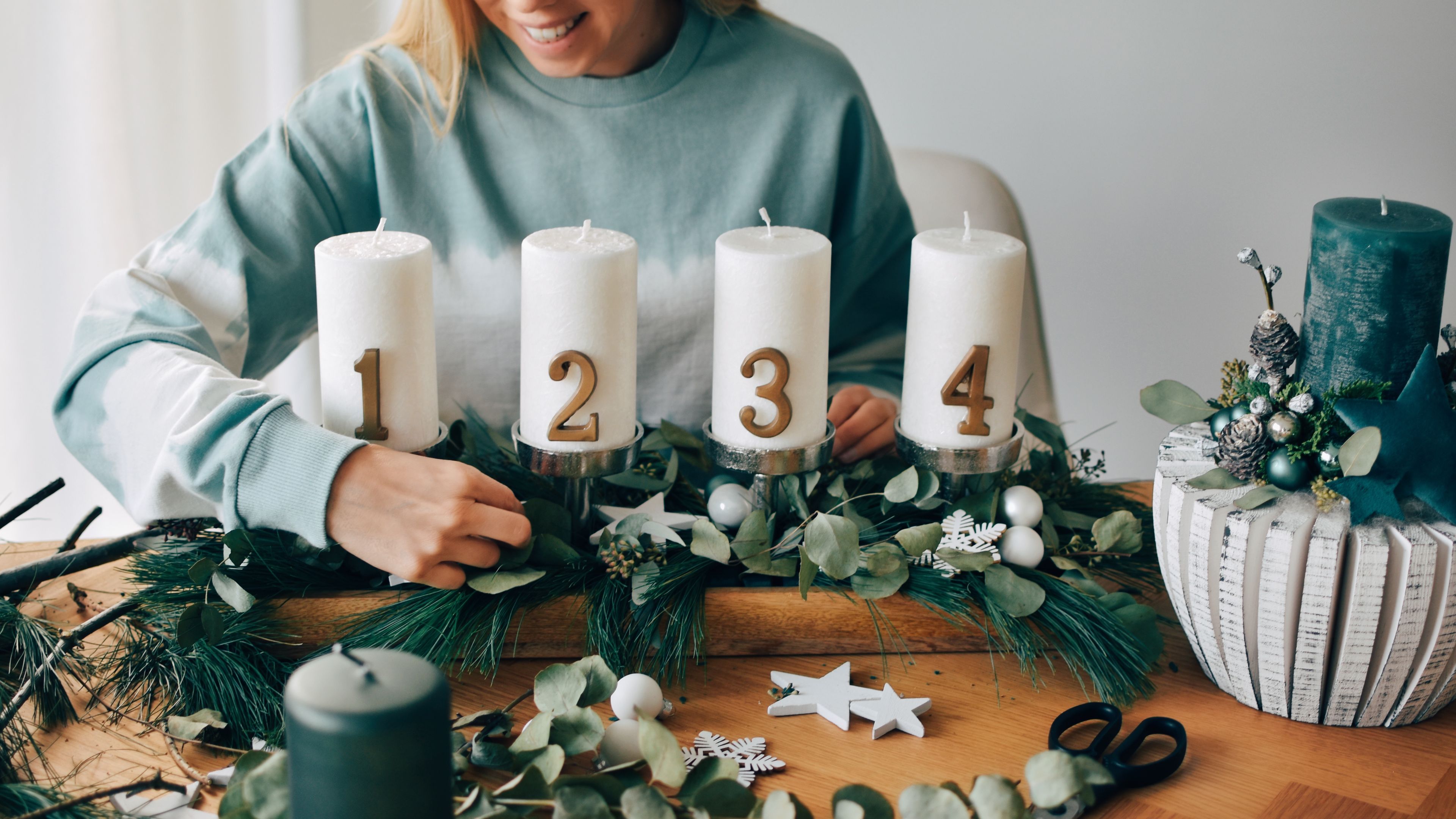 Woman decorating festive Advent arrangements. 