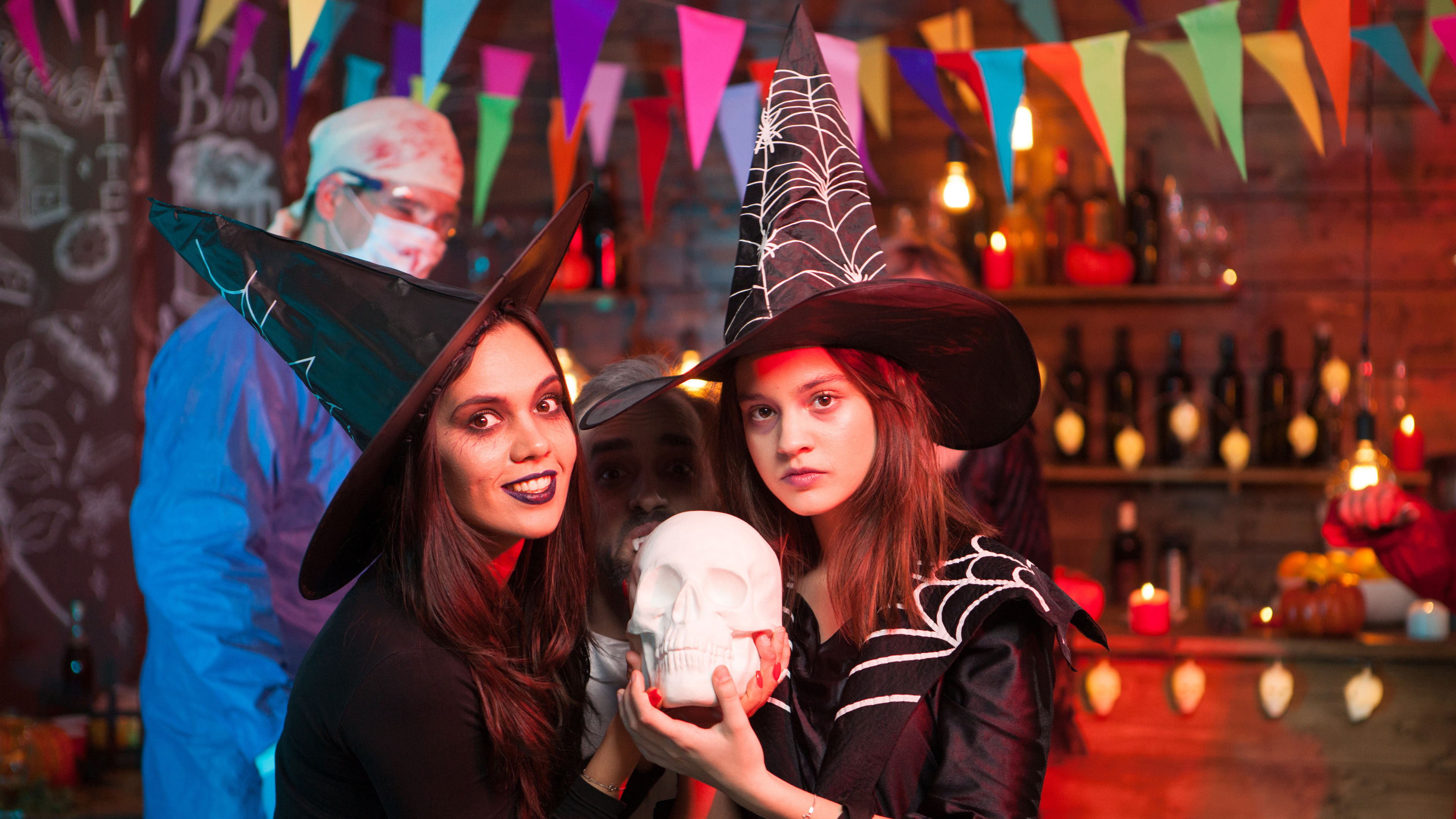 A crazy doctor and two beautiful witches celebrating together in a lively and festive atmosphere. 
