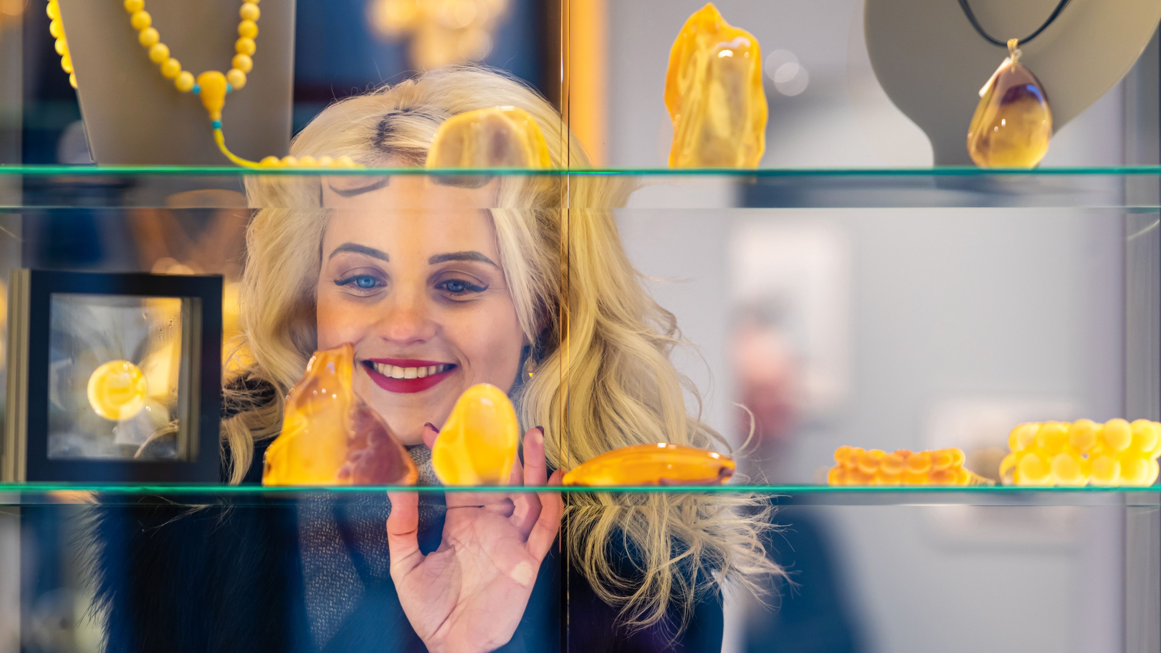 Image of lady looking into the store at jewellery 
