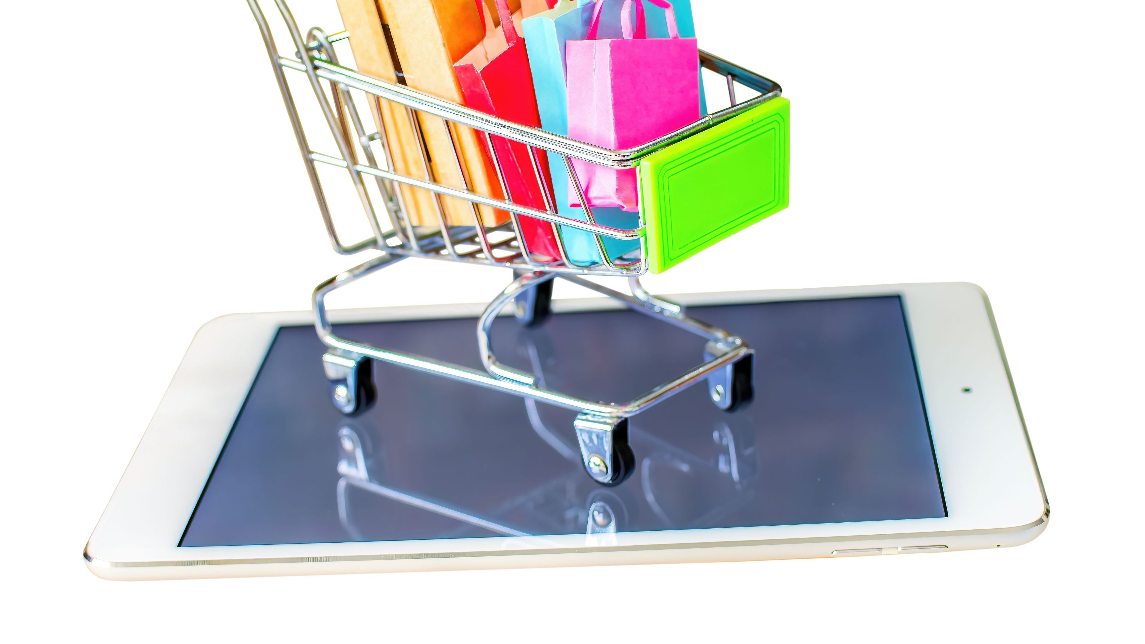 A small cart full of shopping bags placed on a tablet 

