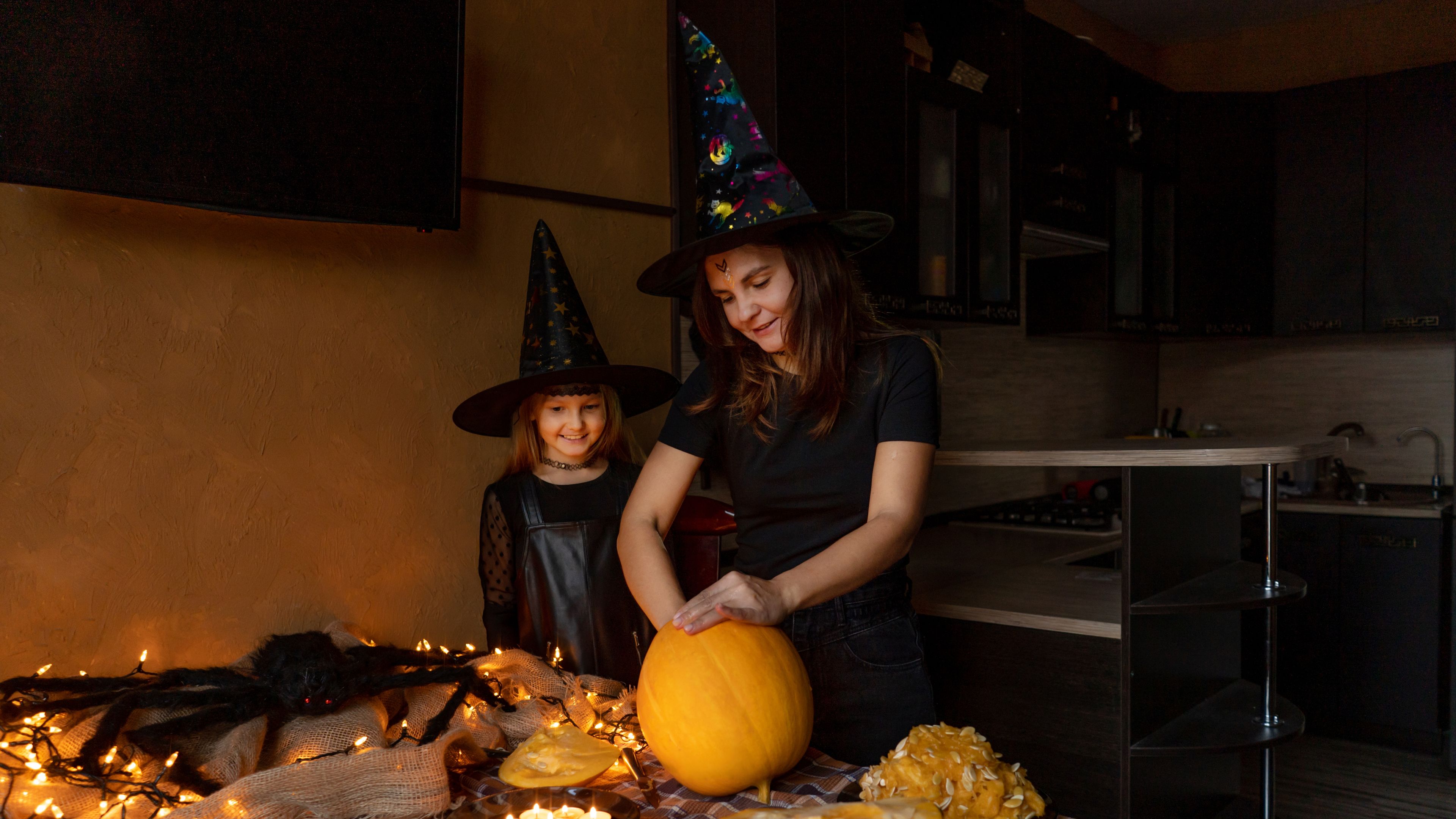 A mother and daughter carving a pumpkin together, preparing for Halloween festivities. 