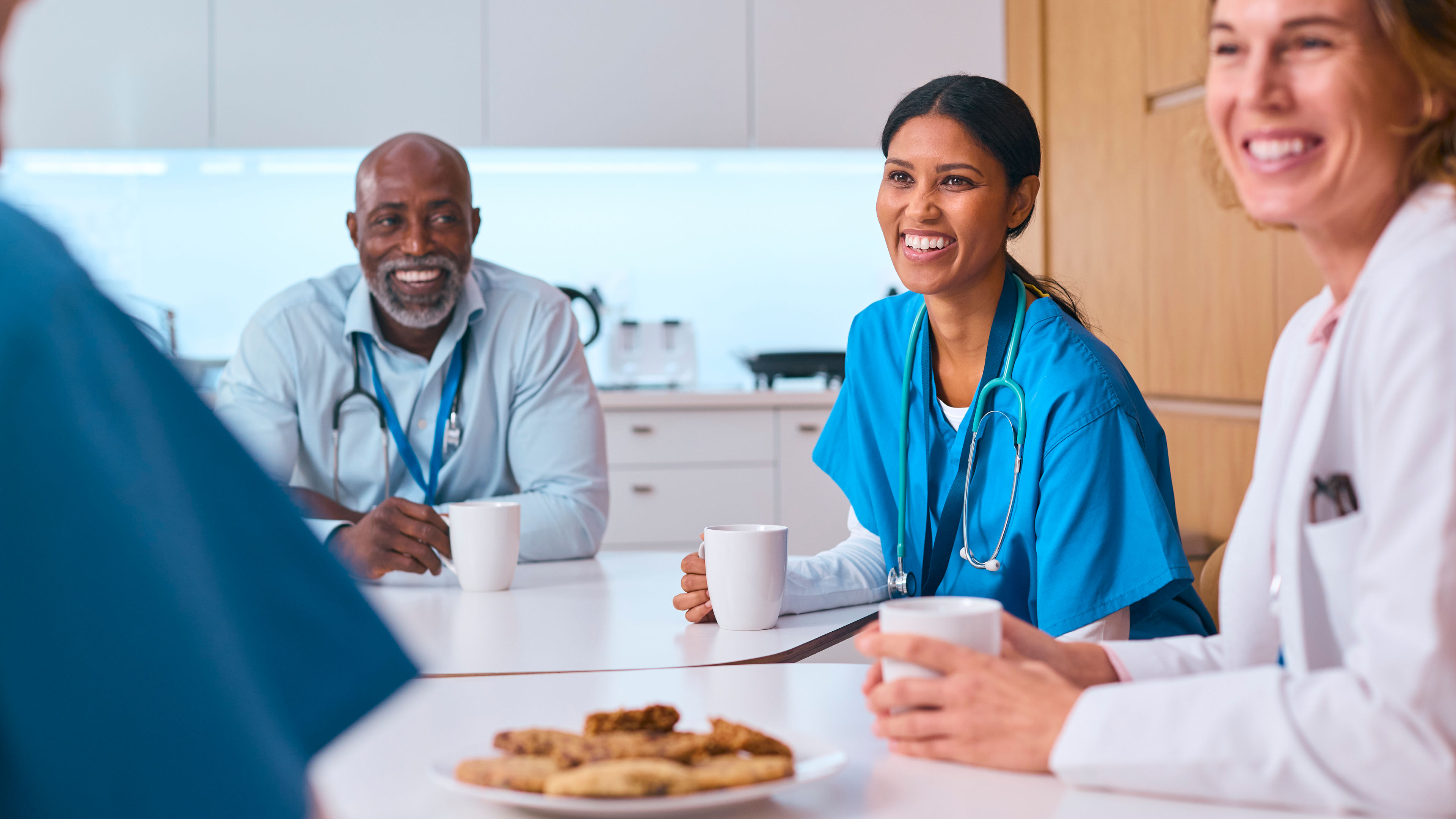 Multi Cultural Medical Team Taking Coffee Break In Modern Hospital Kitchen. 