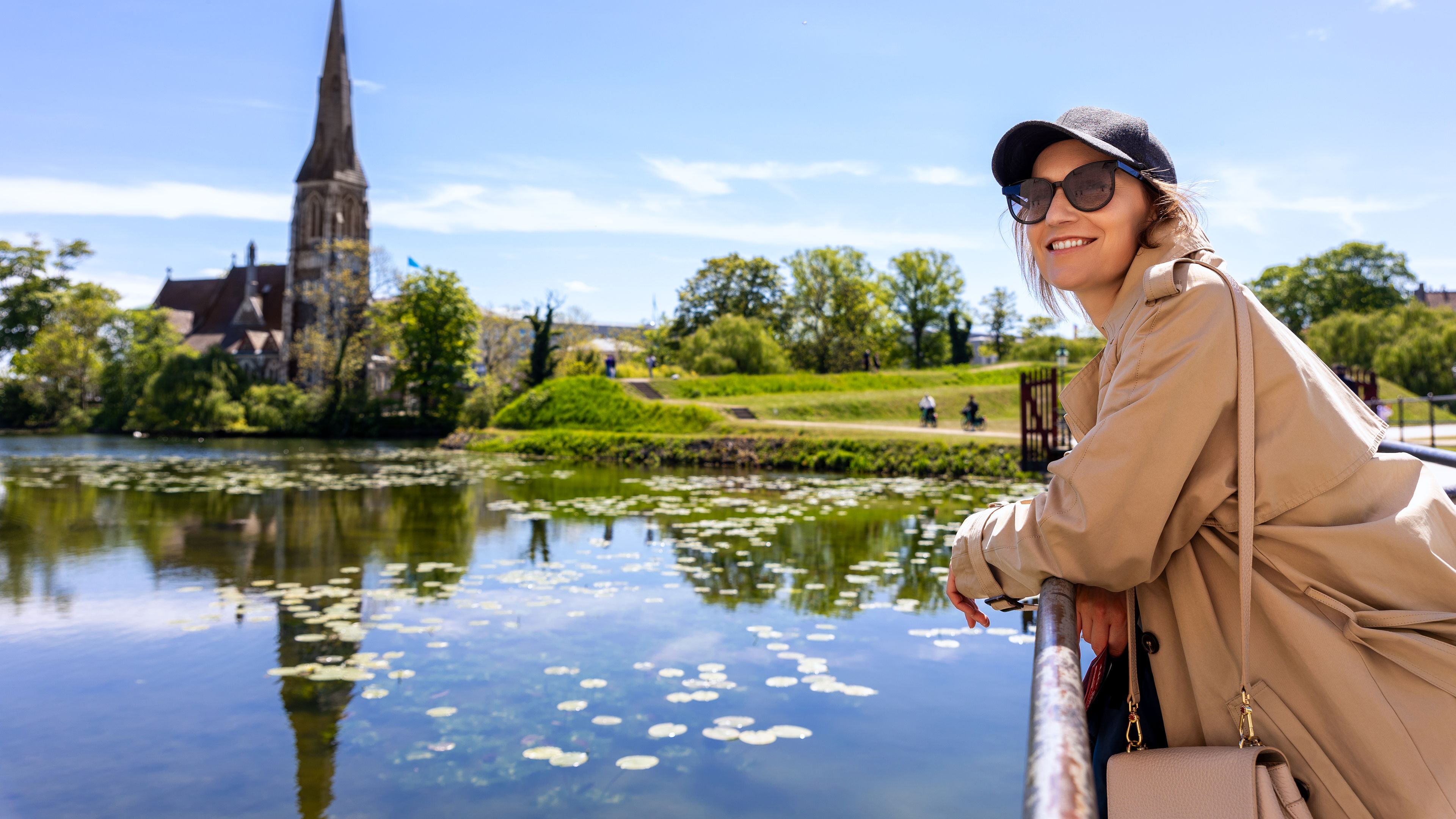 Portrait young beautiful happy smiling womane wear biege trench coat enjoy walking Kastellet citadel 