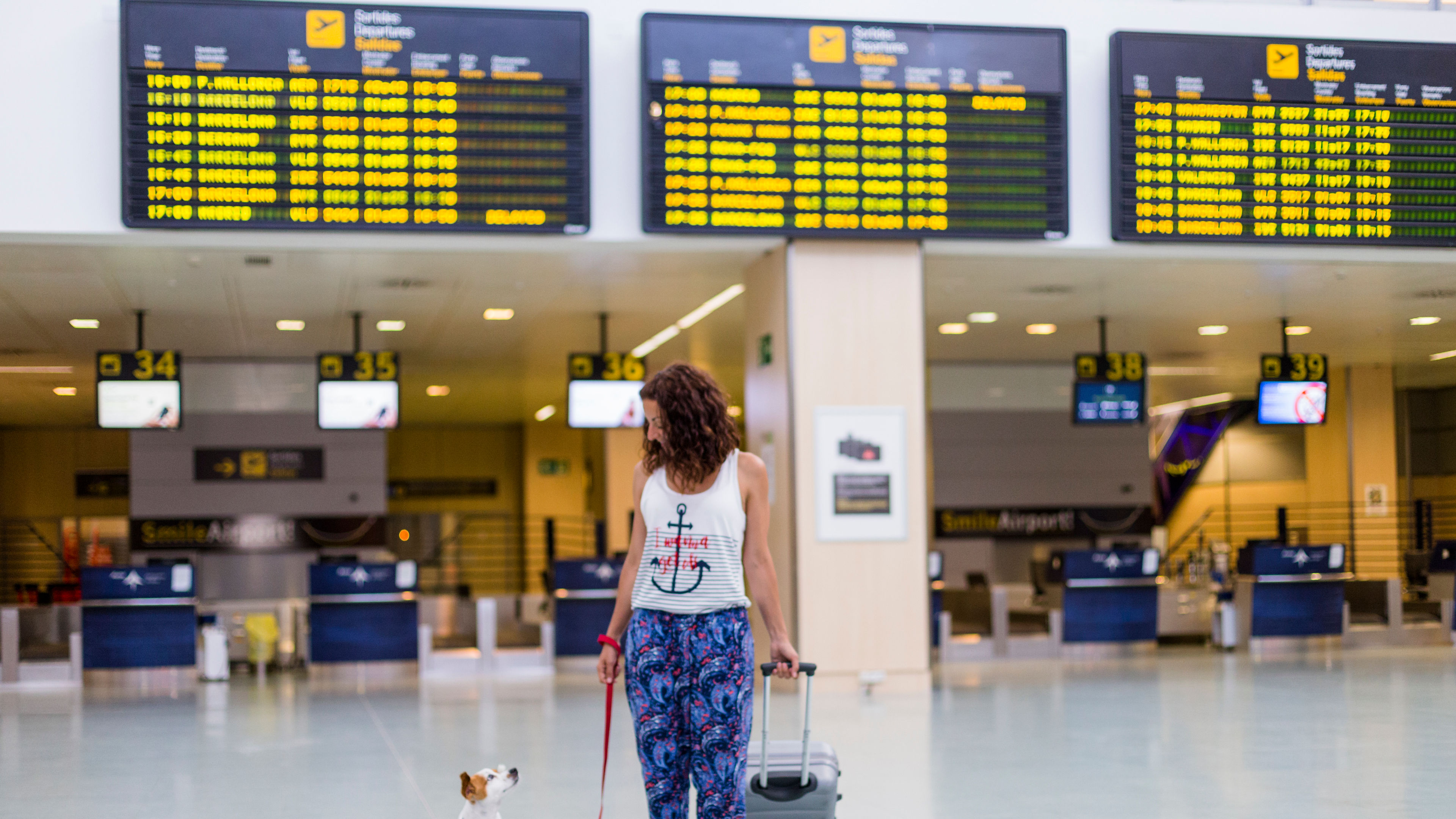 Traveller woman and her dog walking by the airport 