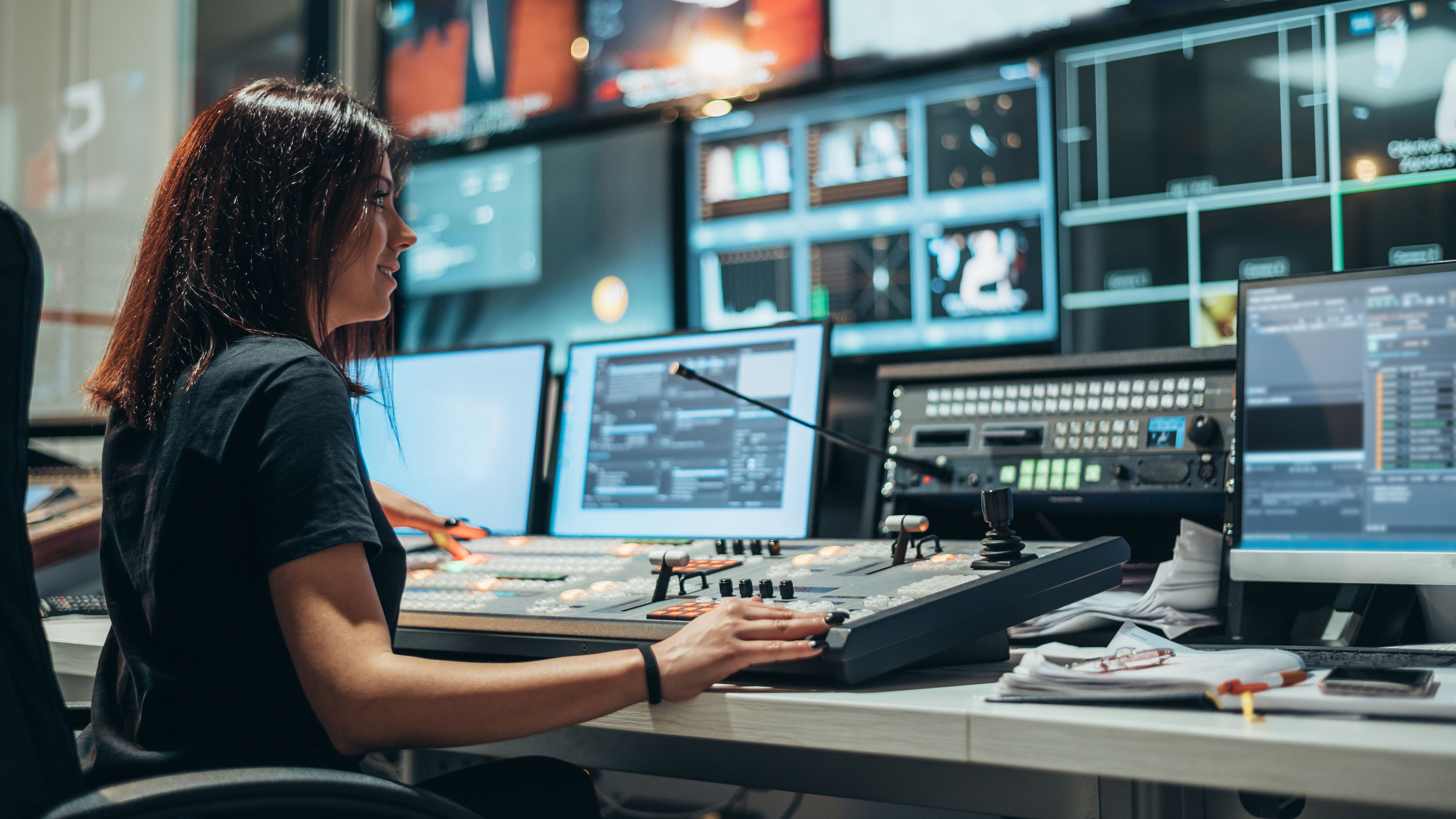 Young beautiful woman working in a broadcast control room on a tv station 
